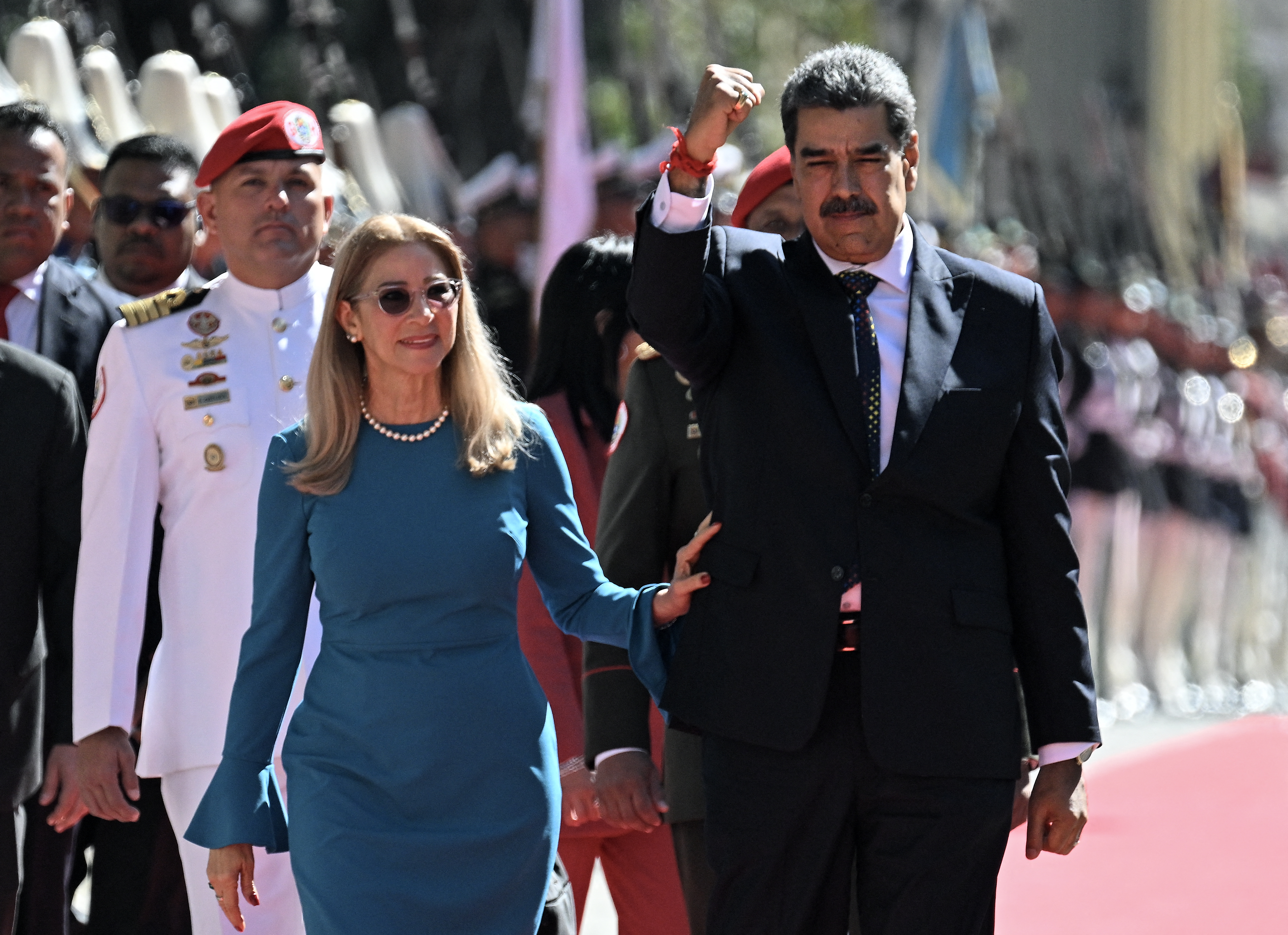 Venezuela's President Nicolas Maduro (R) gestures next to First Lady Cilia Flores on arrival at the Capitolio for the presidential inauguration, in Caracas on January 10, 2025. Maduro, in power since 2013, will take the oath of office for a third term despite a global outcry that brought thousands out in protest on the ceremony's eve. (Photo by Federico PARRA / AFP)