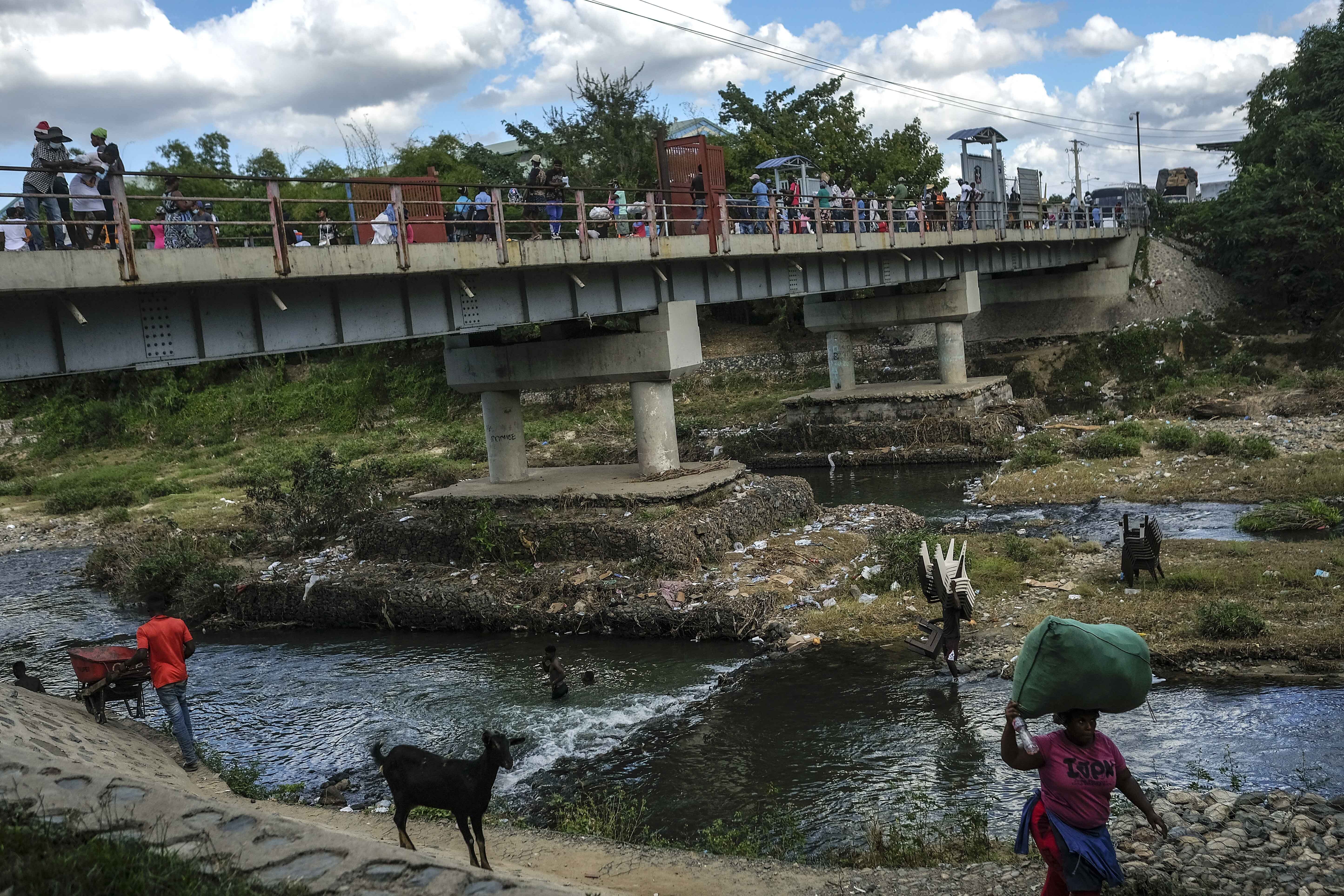 ARCHIVO - La gente se baña en el río Masacre, llamado así por una sangrienta batalla entre colonizadores españoles y franceses en el siglo XVIII, en la frontera con Haití en Juana Méndez, República Dominicana, el 19 de noviembre de 2021. El presidente de República Dominicana, Luis Abinader, anunció el 11 de septiembre de 2023 que suspendió la emisión de visas a los haitianos. (AP Foto/Matias Delacroix, Archivo)
