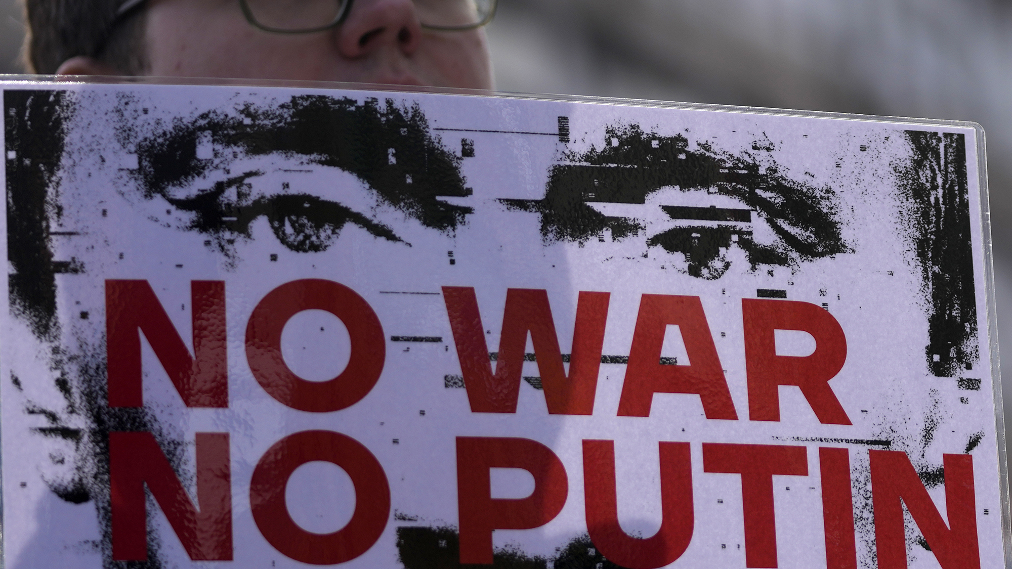 A man holds a banner during a rally to mark the one-year anniversary of Russia's invasion of Ukraine in Belgrade, Serbia, Friday, Feb. 24, 2023. A traditional Slavic ally, Serbia has maintained friendly relations with Russia despite the invasion and has refused to join Western sanctions designed to punish Moscow for the aggression. (AP Photo/Darko Vojinovic)