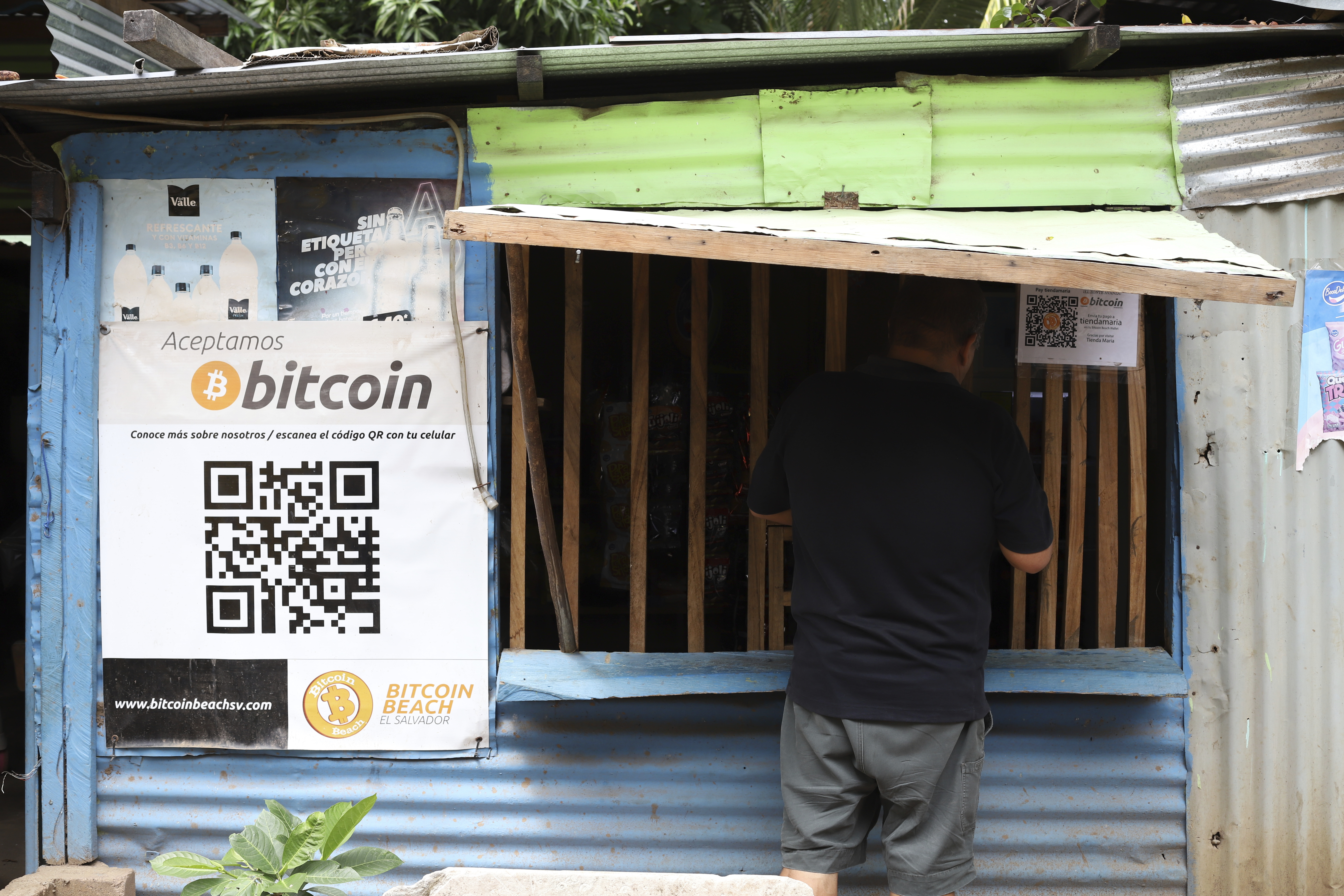 Un trabajador de Hope House, una organización que patrocina el uso de criptomonedas en la playa El Zonte, realiza una compra en una pequeña tienda que acepta Bitcoin, en Tamanique, El Salvador. (AP Foto/Salvador Meléndez)