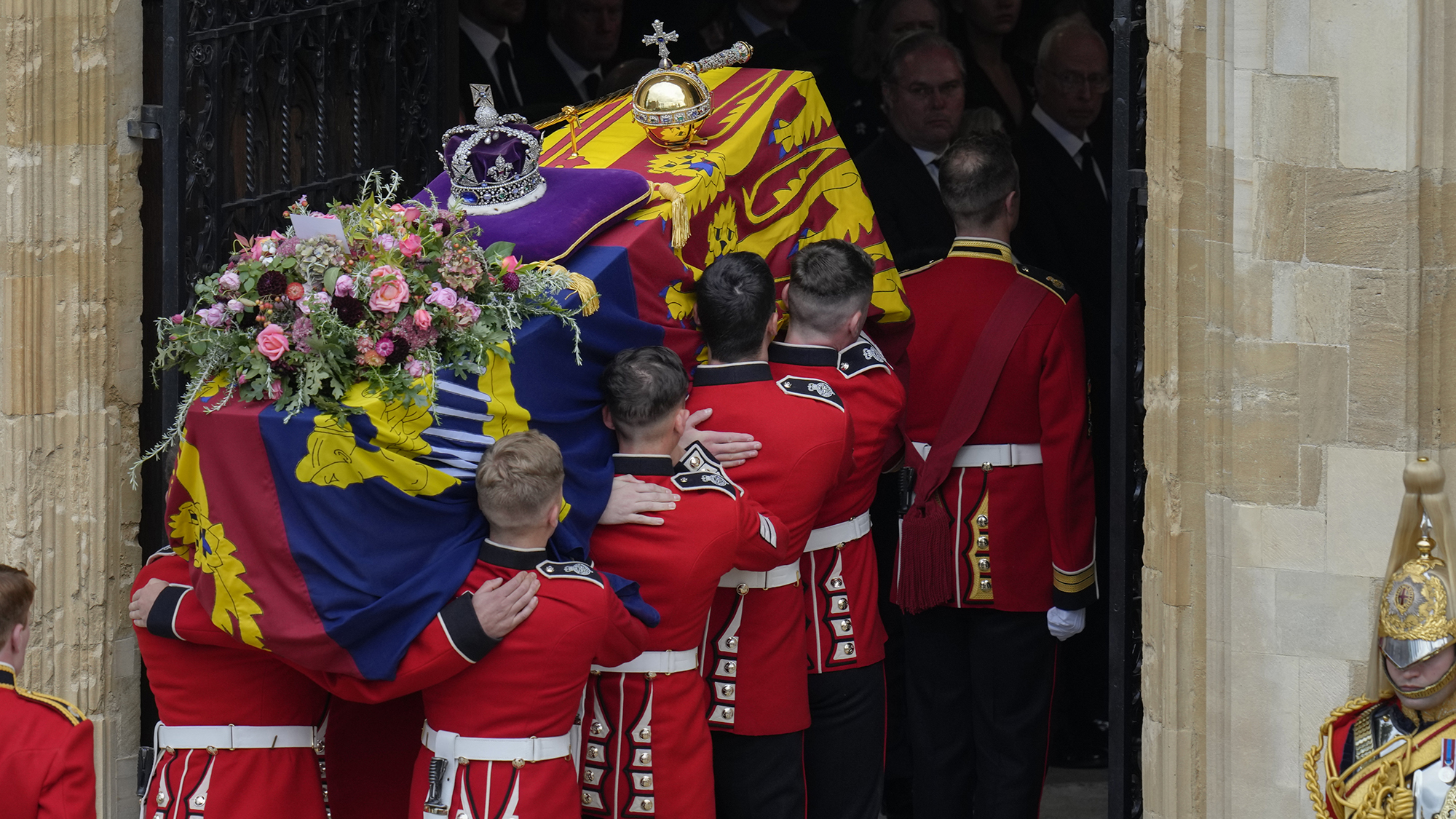 The coffin of Queen Elizabeth II is carried into Saint George's chapel for her funeral at Windsor castle, Britain, Monday, Sept. 19, 2022. The Queen, who died aged 96 on Sept. 8, will be buried at Windsor alongside her late husband, Prince Philip, who died last year. (AP Photo/Kirsty Wigglesworth, Pool)