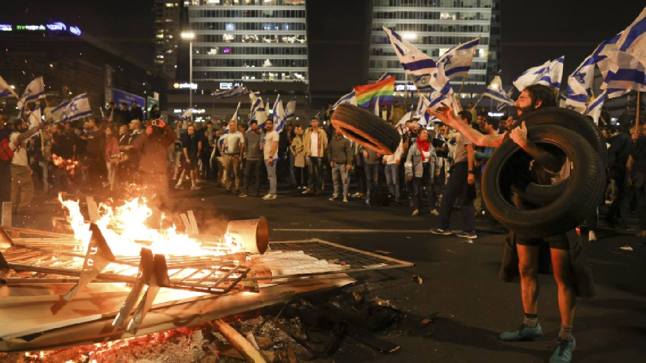 Los israelíes que se oponen al plan de reforma judicial del primer ministro Benjamin Netanyahu encendieron hogueras y bloquearon una carretera durante una protesta momentos después de que el líder israelí despidiera a su ministro de Defensa.