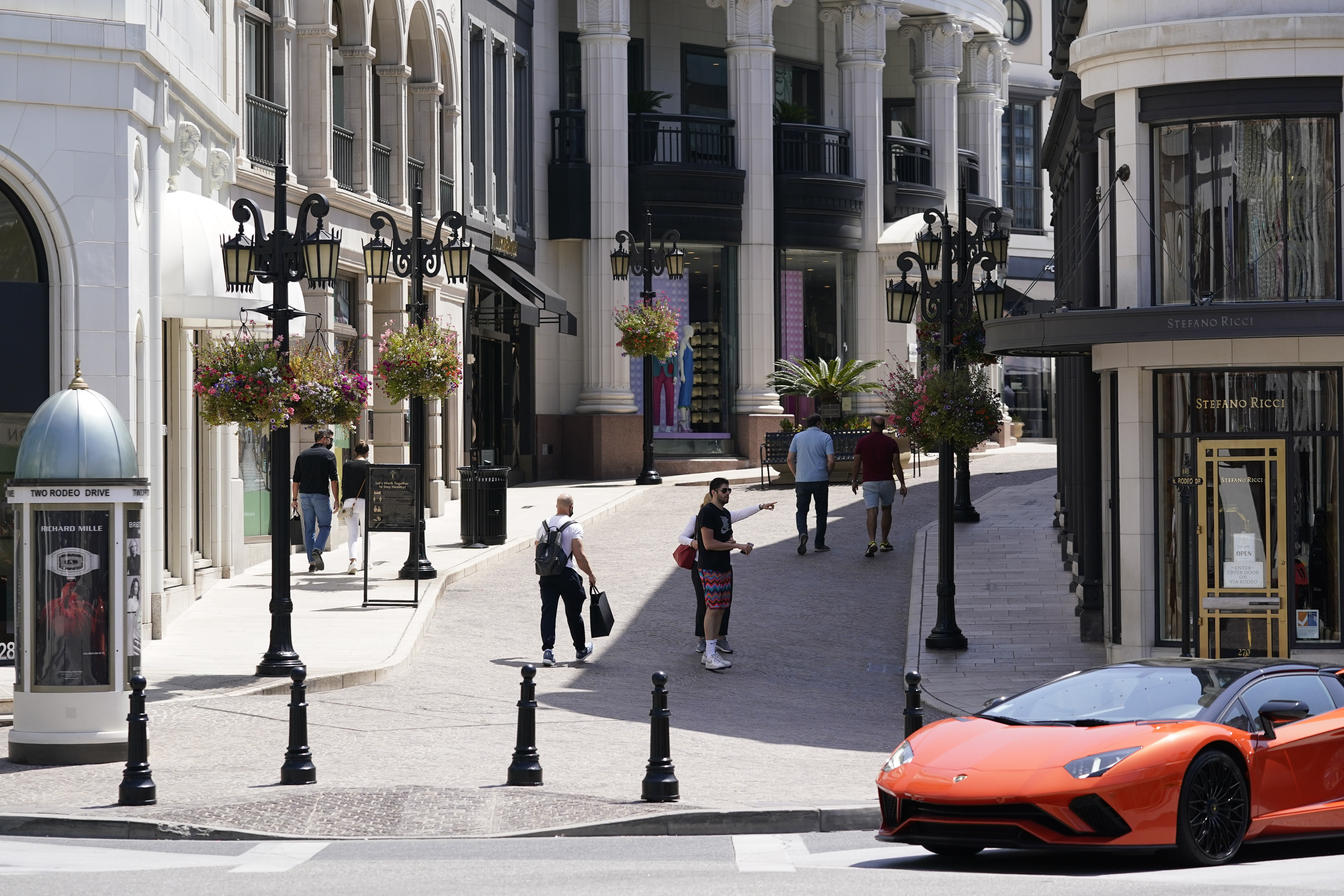 Personas caminando sin tapabocas en Beverly Hills, Calif. (AP Photo/Ashley Landis)