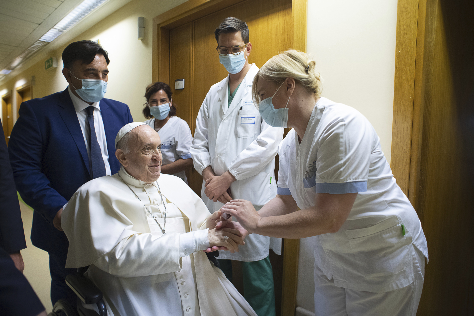 El papa Francisco saluda a personal del hospital, sentado en una silla de ruedas dentro de la Policlínica Agostino Gemelli en Roma, el domingo 11 de julio de 202. (Vatican Media via AP)