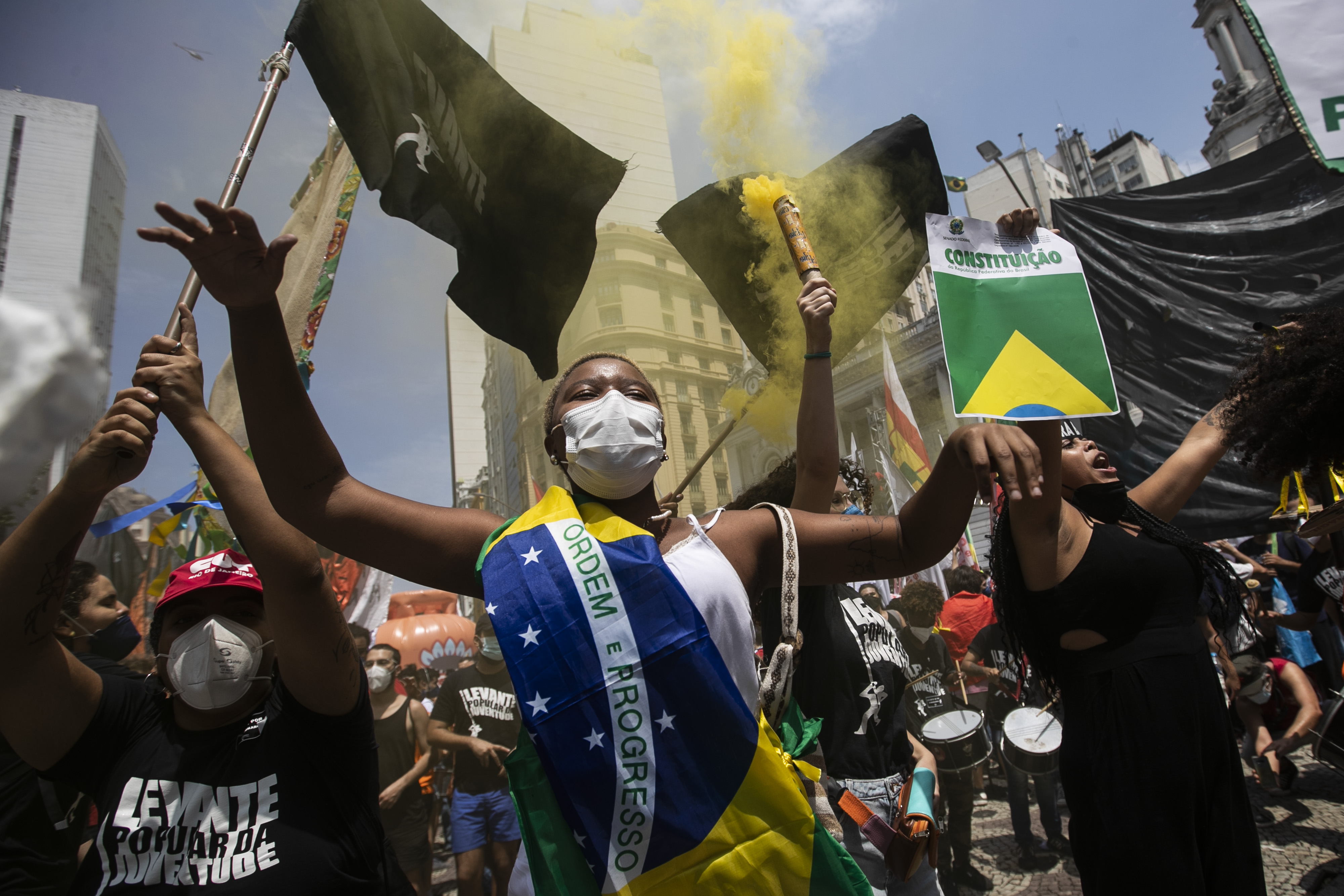A woman, wrapped in a Brazilian national flag, chats slogans during a protest against Brazilian President Jair Bolsonaro calling for his impeachment over his government’s handling of the pandemic and accusations of corruption in the purchases of COVID-19 vaccines, in Rio de Janeiro, Brazil, Saturday, Oct. 2, 2021. (AP Photo/Bruna Prado)