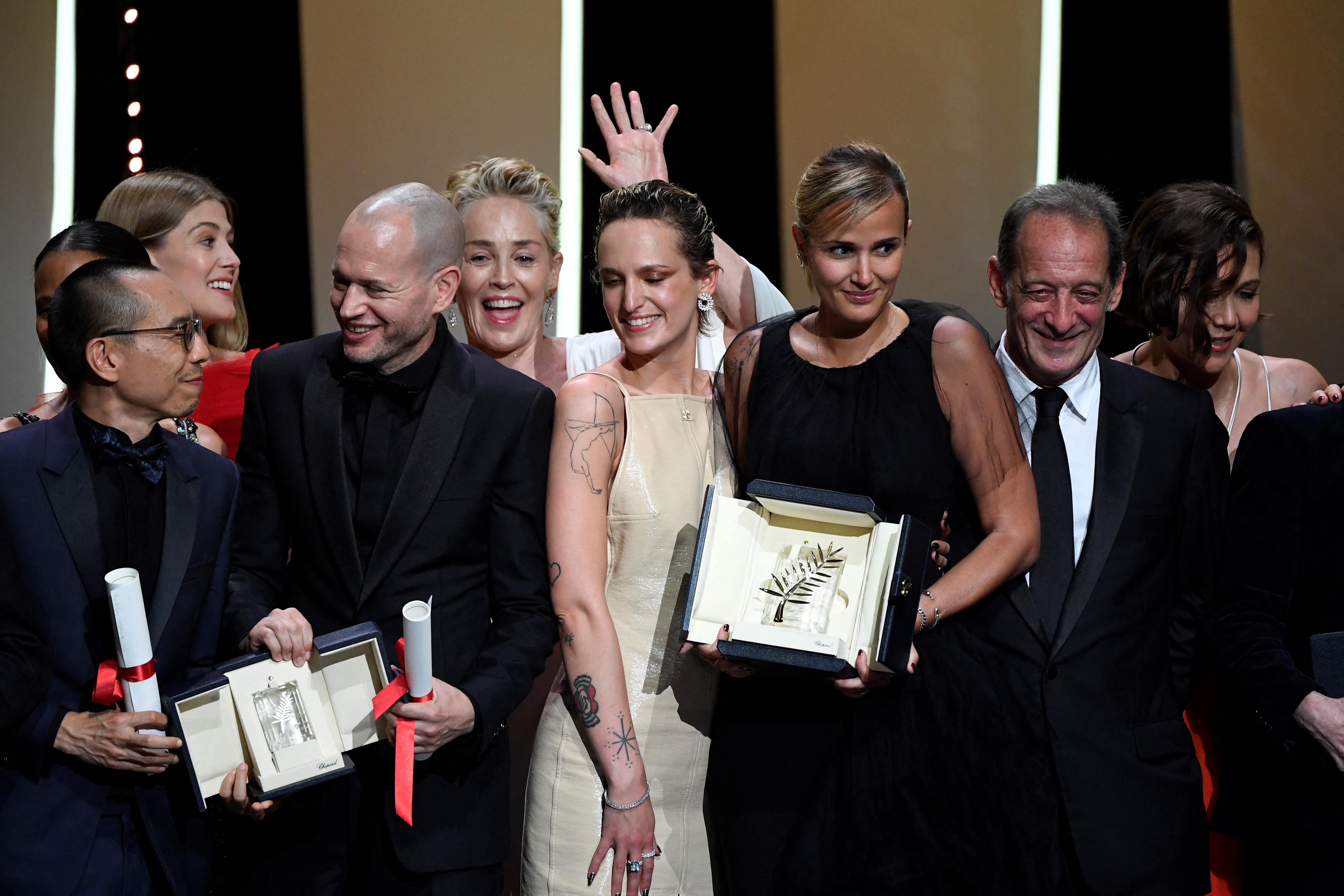 French director Julia Ducournau (C) poses on stage with guests and laureates after she won the Palme d'Or for her film "Titane" during the closing ceremony of the 74th edition of the Cannes Film Festival in Cannes, southern France, on July 17, 2021. (Photo by CHRISTOPHE SIMON / AFP)