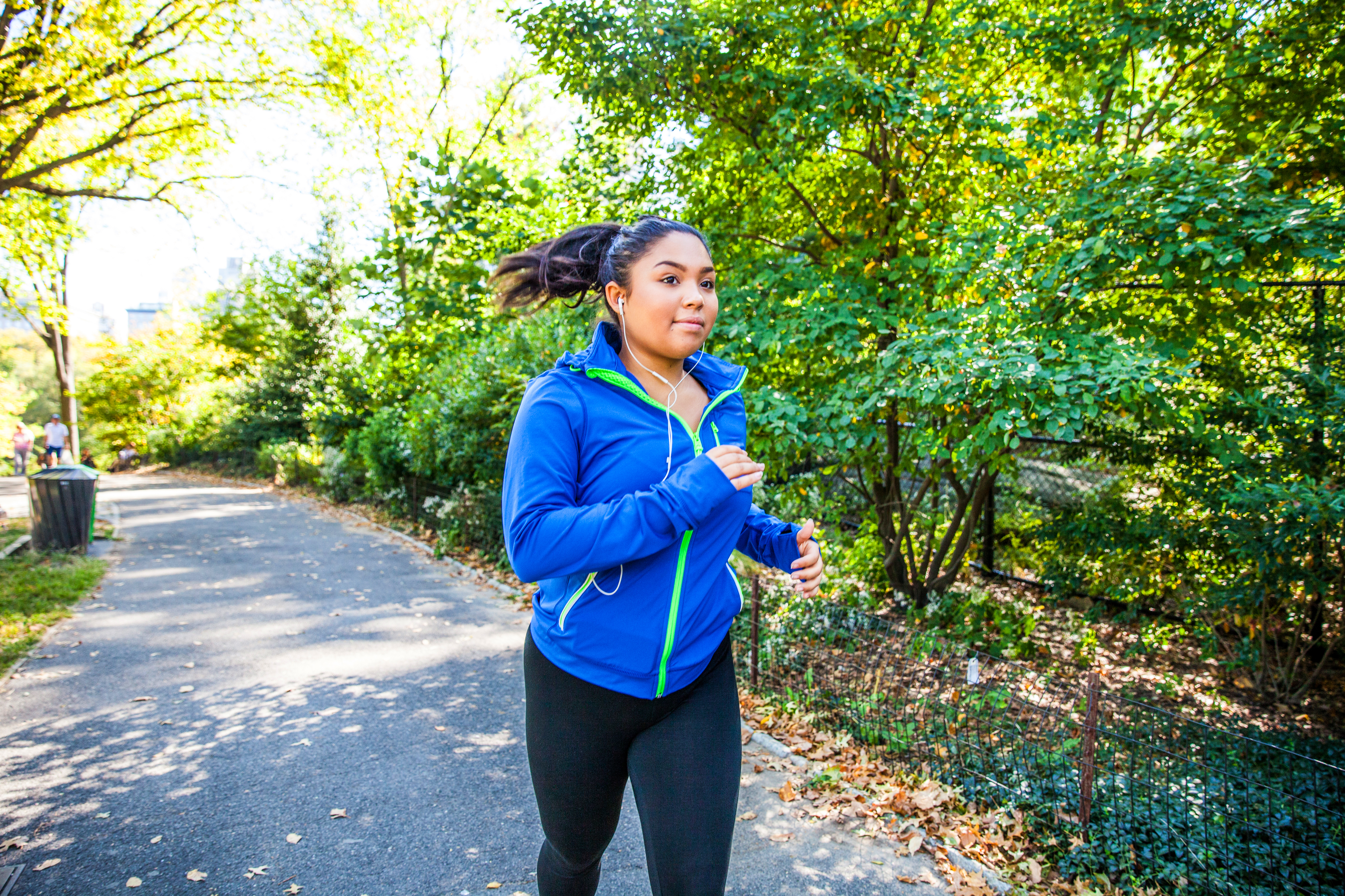 Mujer de talla grande corriendo en Central Park, Nueva York durante un hermoso día.