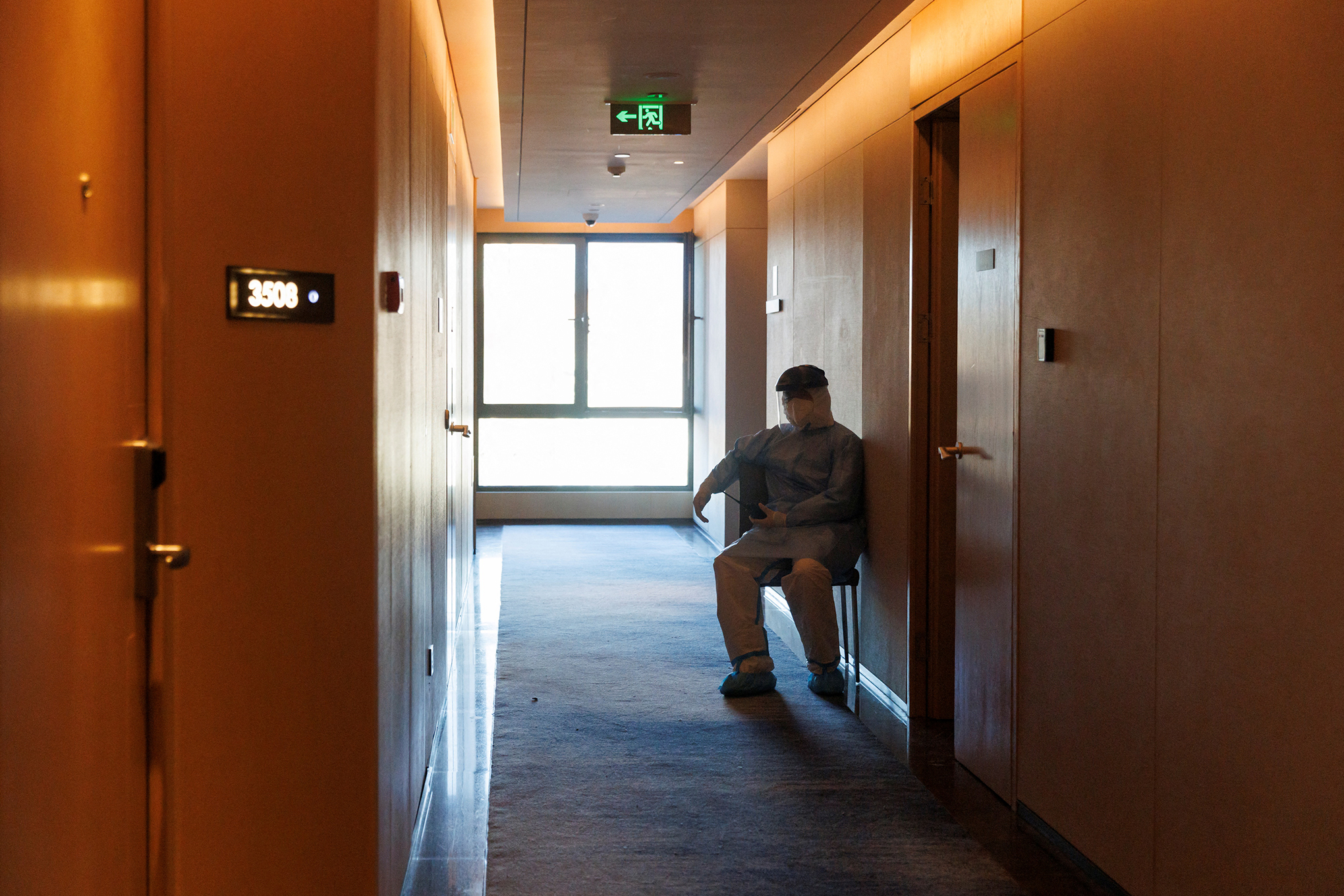 Un miembro del personal que usa un traje como protección contra la enfermedad del coronavirus vigila afuera de las habitaciones de huéspedes en un hotel dentro del circuito cerrado en los Juegos Olímpicos de Invierno de Beijing 2022 en Beijing. Foto REUTERS/Thomas Peter