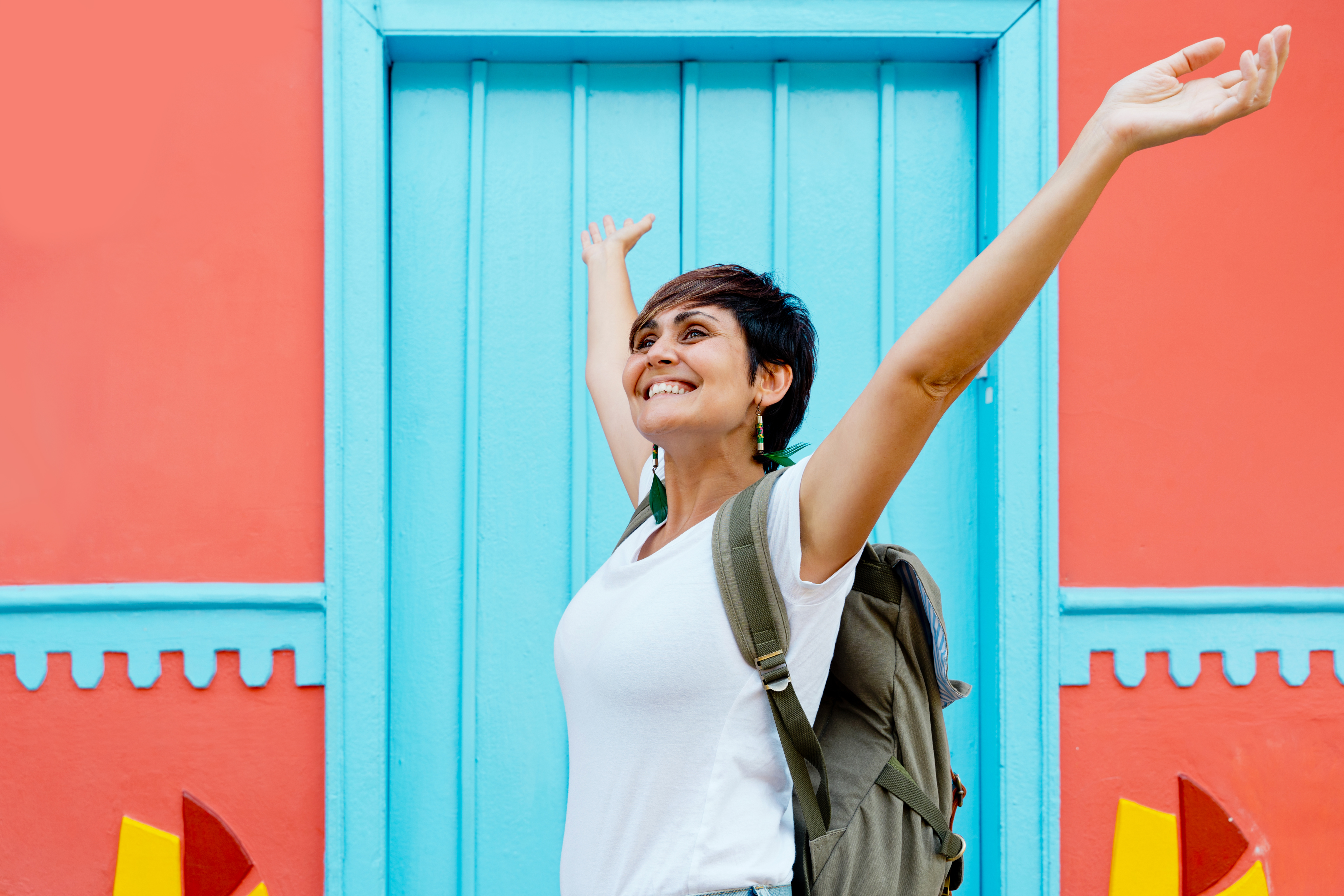 Mujer colombiana haciendo turismo en un pueblo tradicional con casas decoradas.