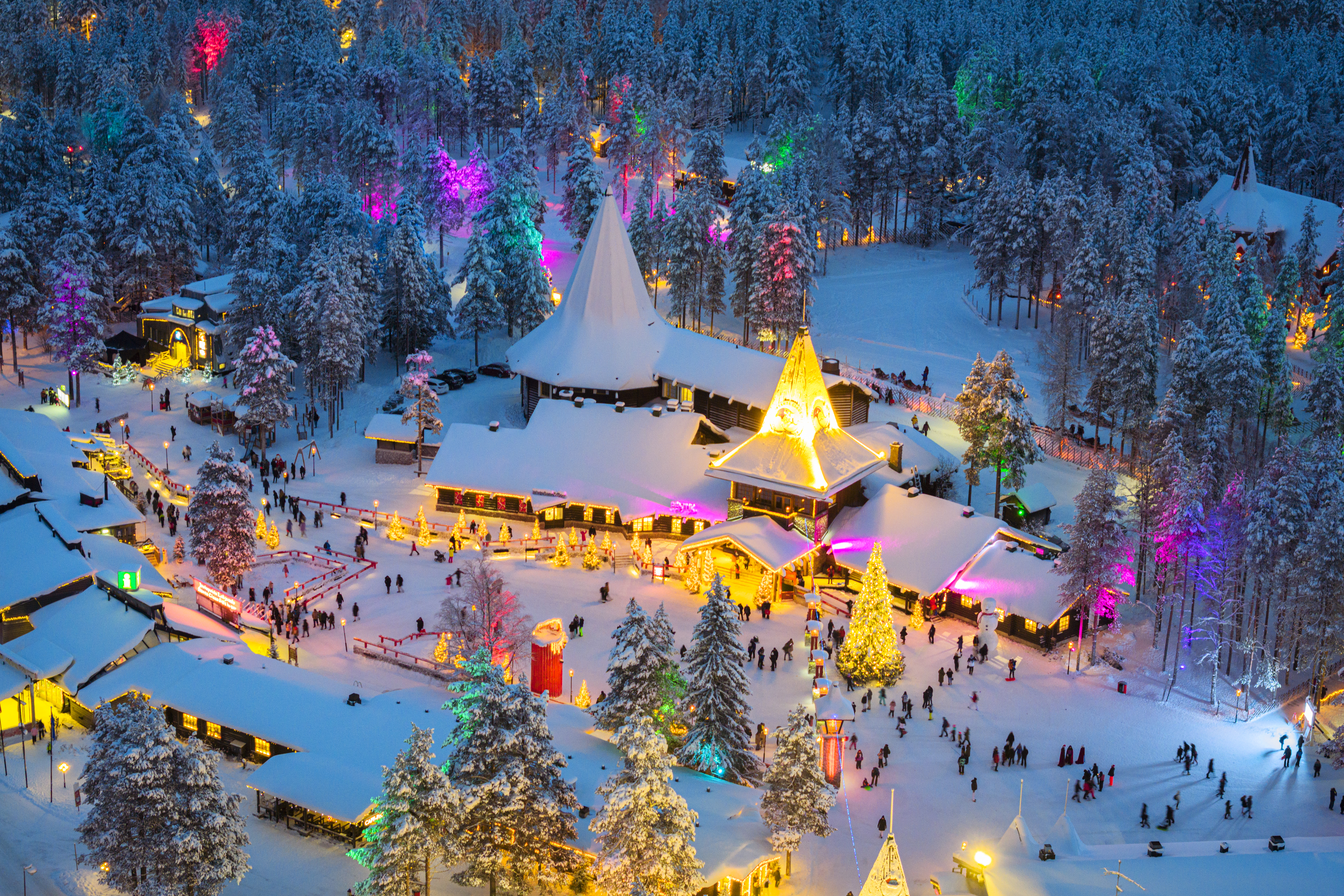 Árbol de Navidad y coloridas luces de hadas en el pueblo de Papá Noel cubierto de nieve en una noche de invierno, Rovaniemi, Laponia, Finlandia.