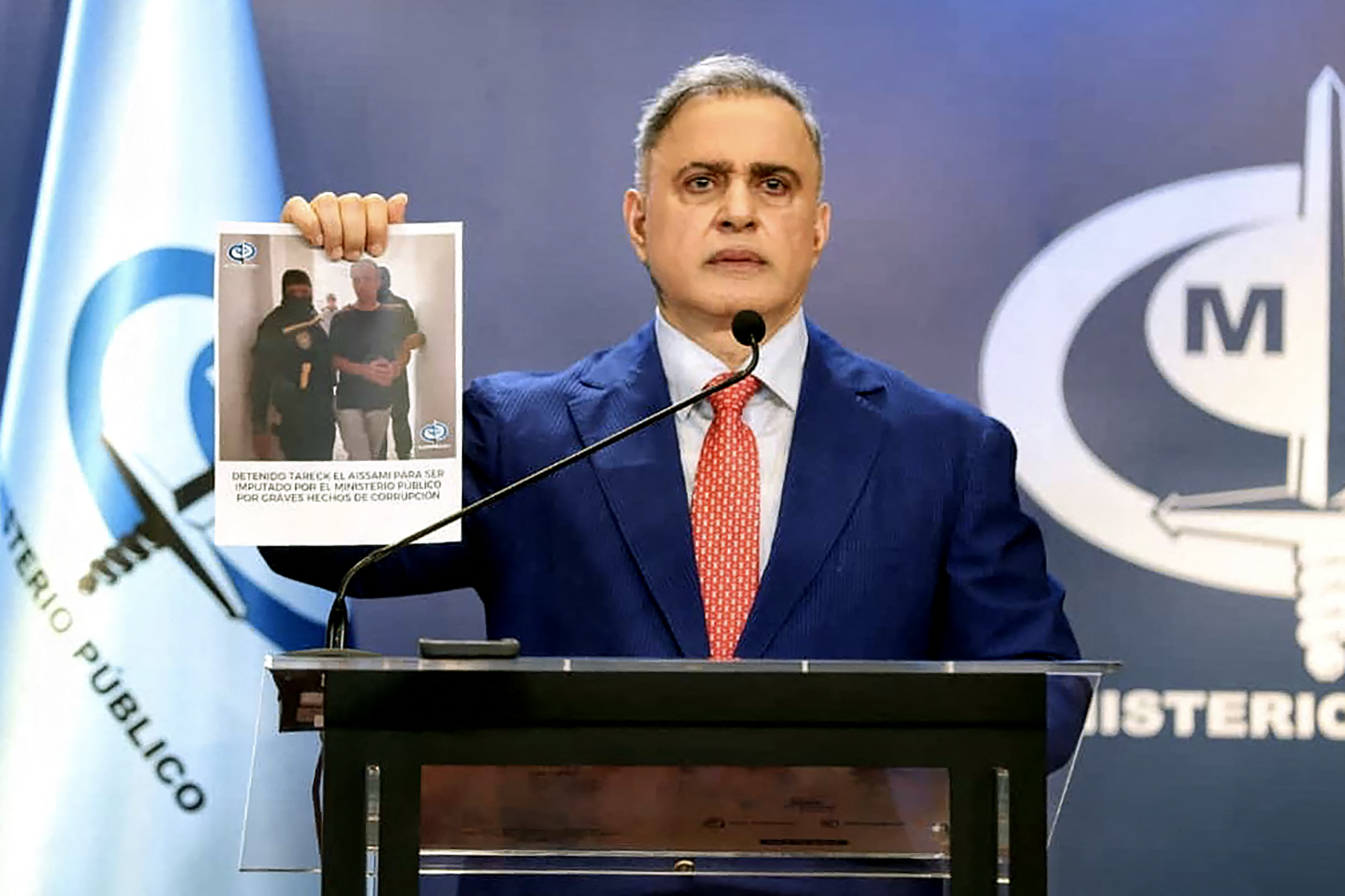 Imagen publicada por el Ministerio Público de Venezuela que muestra al fiscal general de Venezuela, Tarek William Saab, durante una conferencia de prensa en Caracas el 9 de abril de 2024, sosteniendo una fotografía que muestra el arresto del influyente exministro de petróleo Tareck El Aissami, quien había renunciado a su cargo.