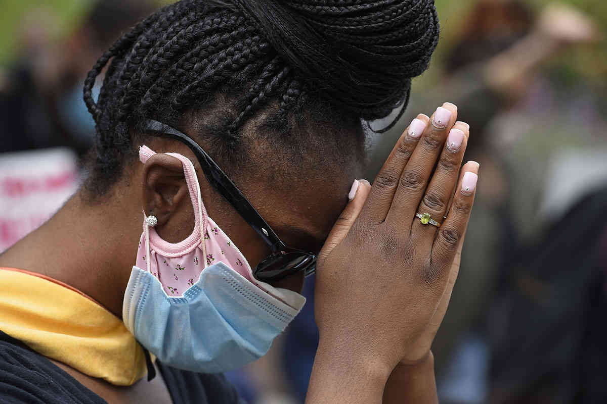 Una manifestante baja la cabeza para rezar durante un momento de silencio después de marchar hacía el Departamento de Policía de Hayward en California, el domingo 31 de mayo de 2020. Foto: Jose Carlos Fajardo / Grupo de Noticias del Área de la Bahía vía AP.