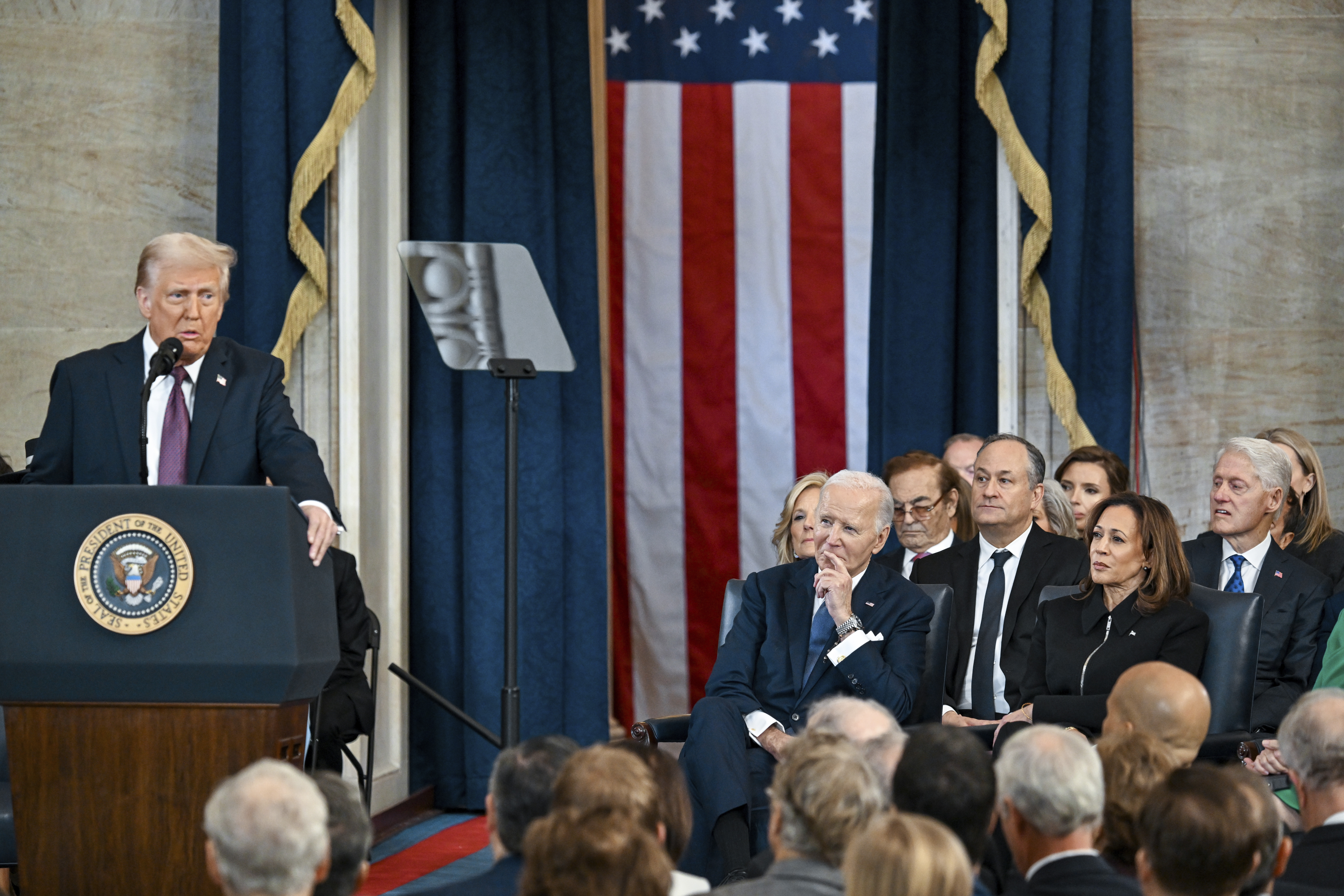 Former President Bill Clinton, from right, former Vice President Kamala Harris, her husband Doug Emhoff and former President Joe Biden listen and President Donald Trump speaks after taking the oath of office during the 60th Presidential Inauguration in the Rotunda of the U.S. Capitol in Washington, Monday, Jan. 20, 2025. (Kenny Holston/The New York Times via AP, Pool)
