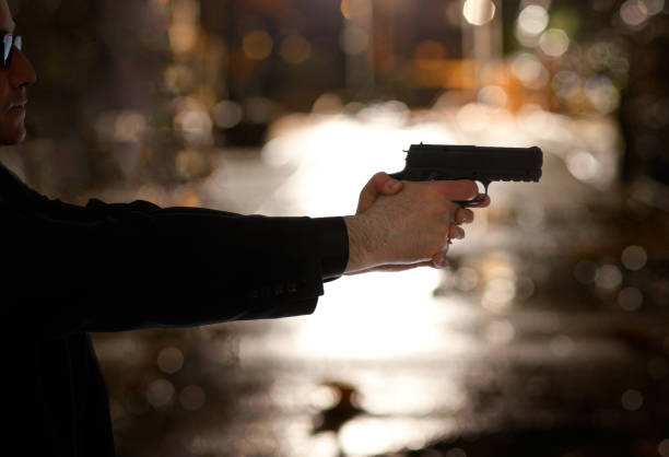 Man pointing gun on city street.