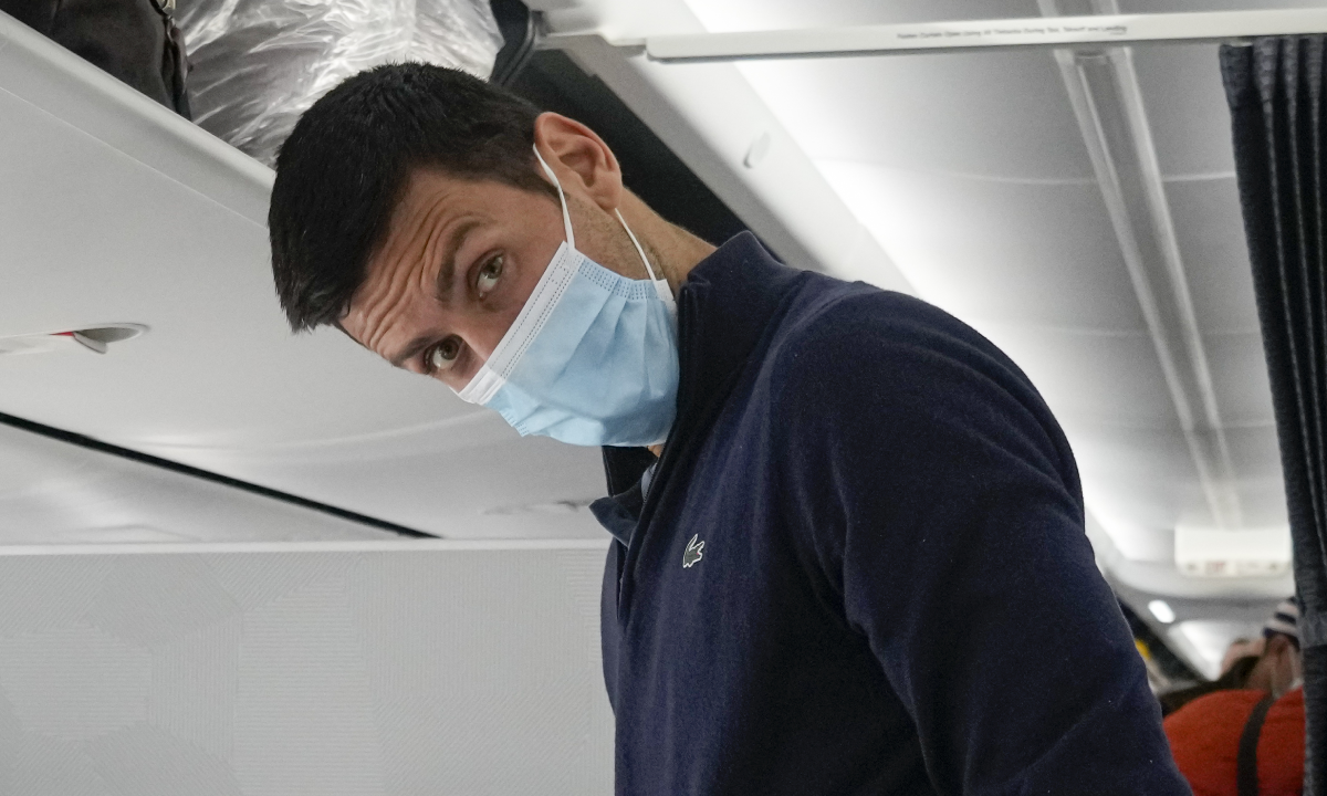 Novak Djokovic se prepara para ocupar su asiento en un avión a Belgrado, en Dubái, Emiratos Árabes Unidos, el lunes 17 de enero de 2022. Djokovic fue deportado de Australia el domingo tras perder una batalla legal para quedarse en el país para defender su título del Abierto de Australia pese a no haberse vacunado contra el COVID-19. (AP Foto/Darko Bandic)