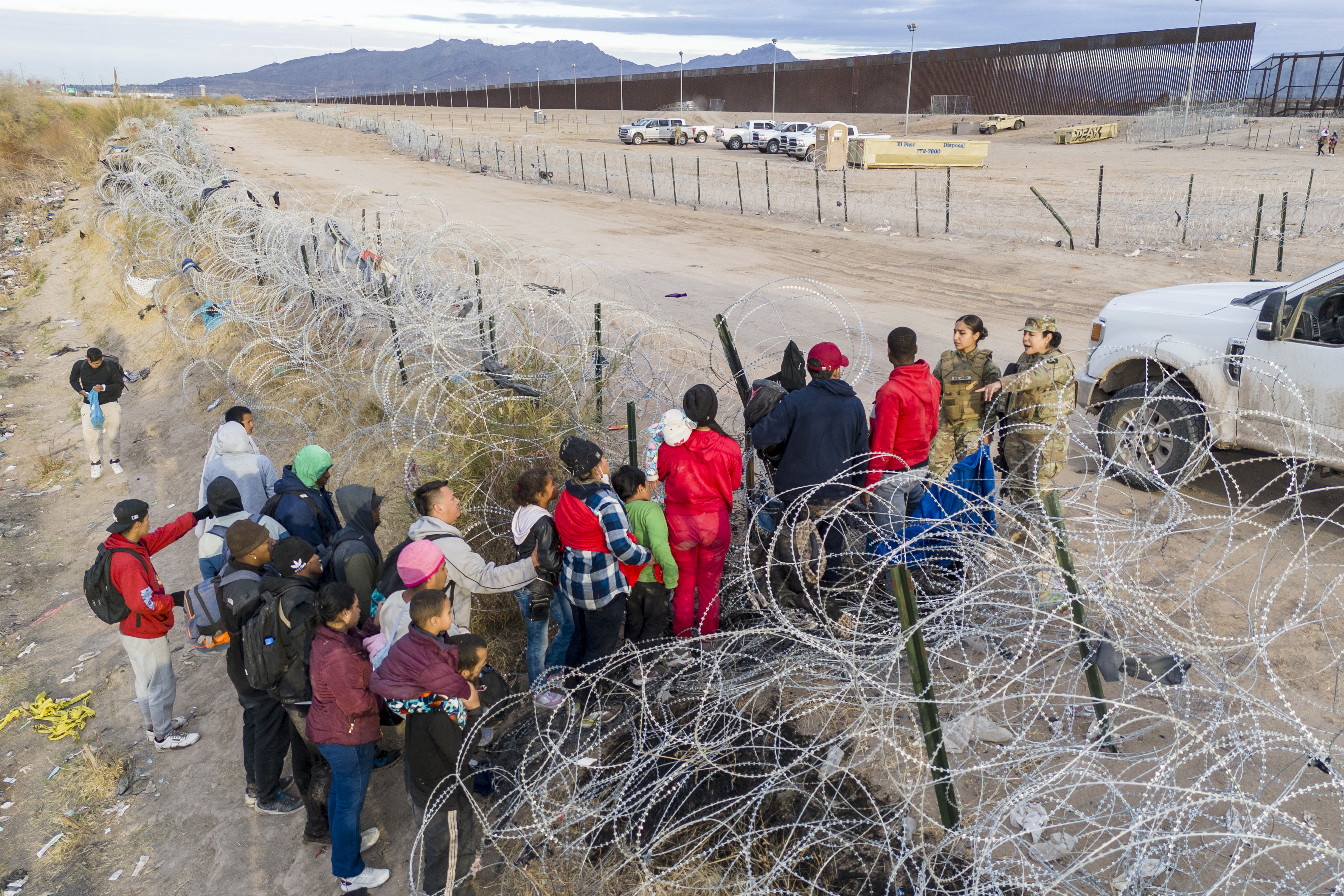 Visto desde una vista aérea, las tropas de la Guardia Nacional de Texas detienen a los inmigrantes que intentan pasar a través de alambre de púas después de cruzar la frontera hacia El Paso, Texas desde El Paso, Texas.
