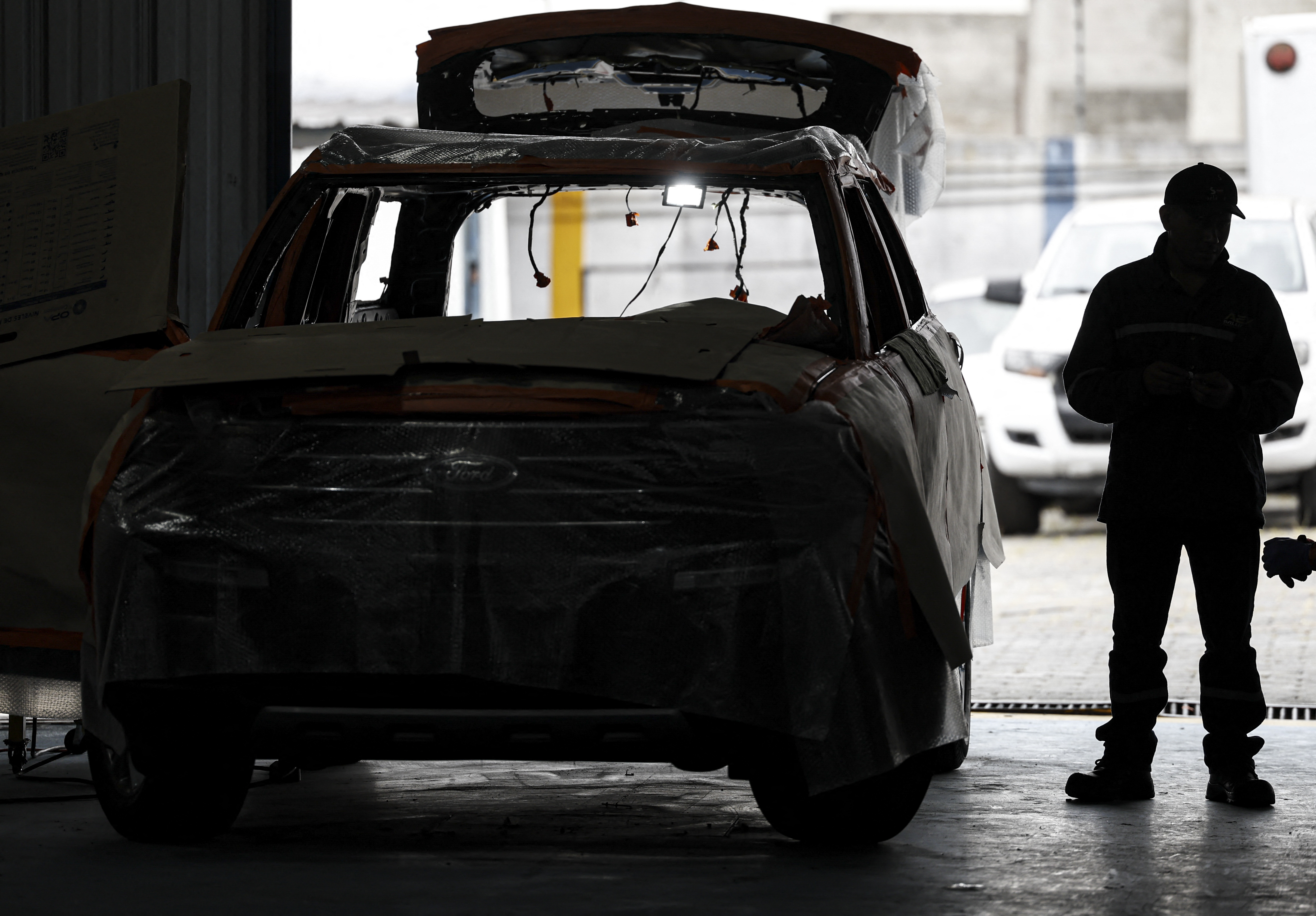 Un mecánico trabaja para blindar un vehículo en el taller de la empresa de seguridad Auto Express en Quito el 15 de agosto de 2023. Los propietarios de vehículos de alta gama pagan fortunas para blindarlos contra el narcotráfico y la violencia de las pandillas, en medio de un "boom" en la industria de seguridad de Ecuador. (Foto por MARTÍN BERNETTI / AFP).