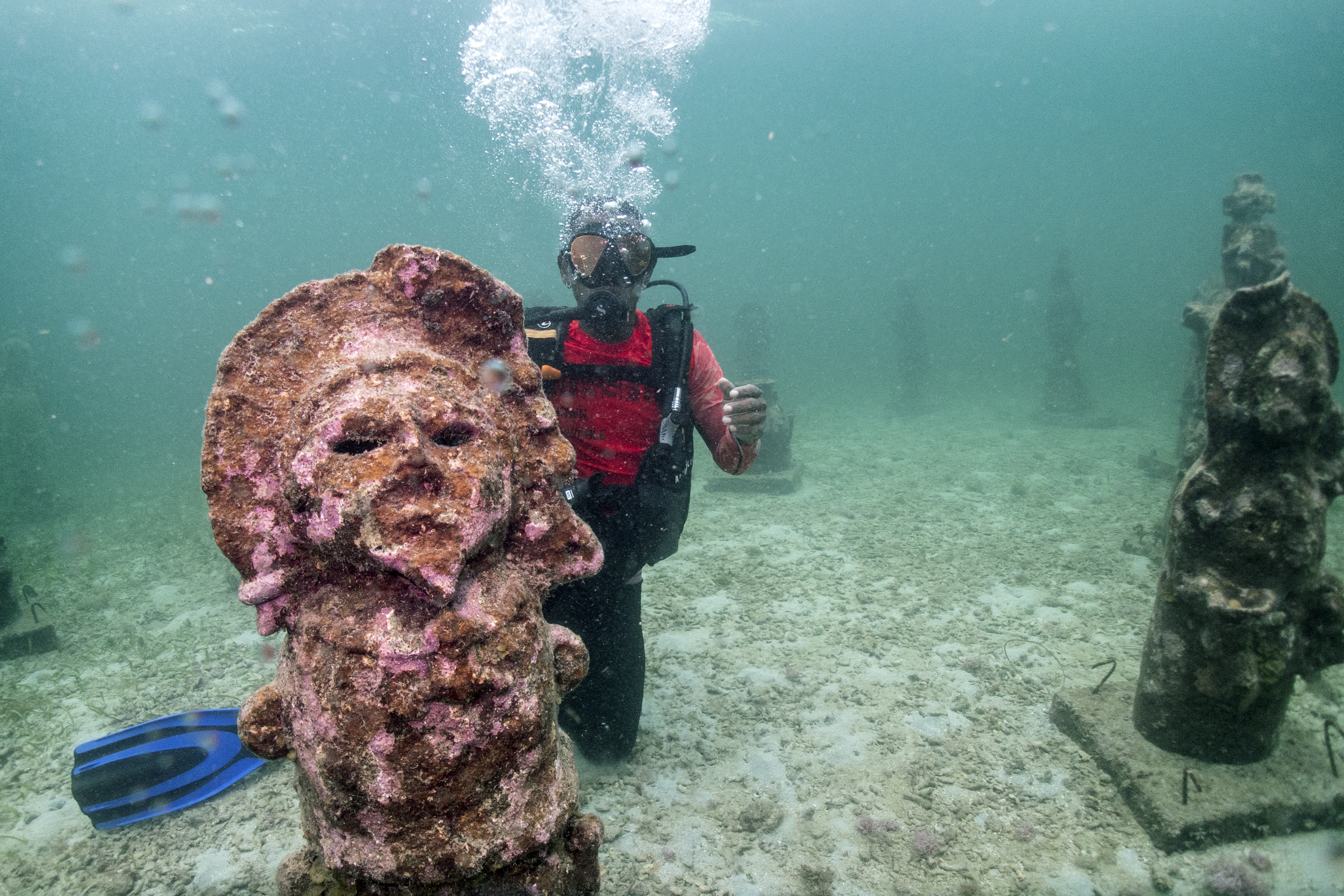 El guía Orlis Navas bucea en el MUSZIF underwater museum in Isla Fuerte, Bolivar department, Colombia, on May 22, 2024. In the Colombian Caribbean an underwater museum protects coral reefs threatened by tourism and climate change. (Photo by Luis ACOSTA / AFP)
