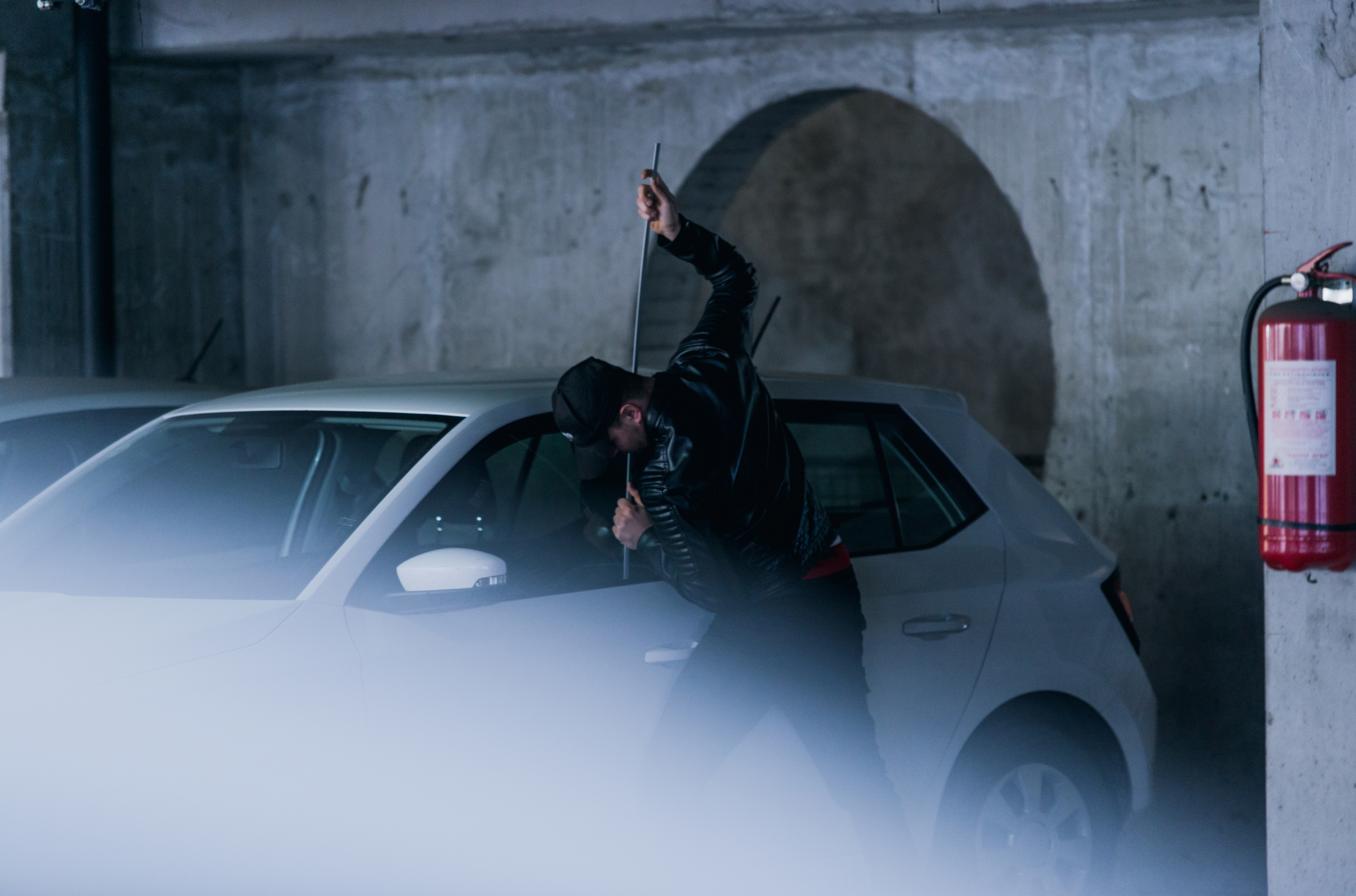 Joven ladrón está tratando de robar un auto en el estacionamiento robo carro