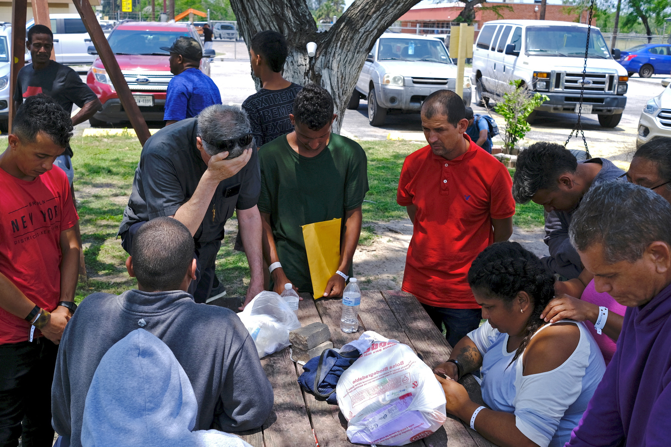 Father Kevin Collins, OMI, Pastor at St. Eugene de Mazenod Parish places his hand onto his forehead in prayer with migrants at Ozanam Center, a shelter for migrants and homeless, after a deadly incident where a car ran into pedestrians at a bus stop nearby in Brownsville, Texas, U.S. May 7, 2023.  REUTERS/Miguel Roberts NO RESALES. NO ARCHIVES.