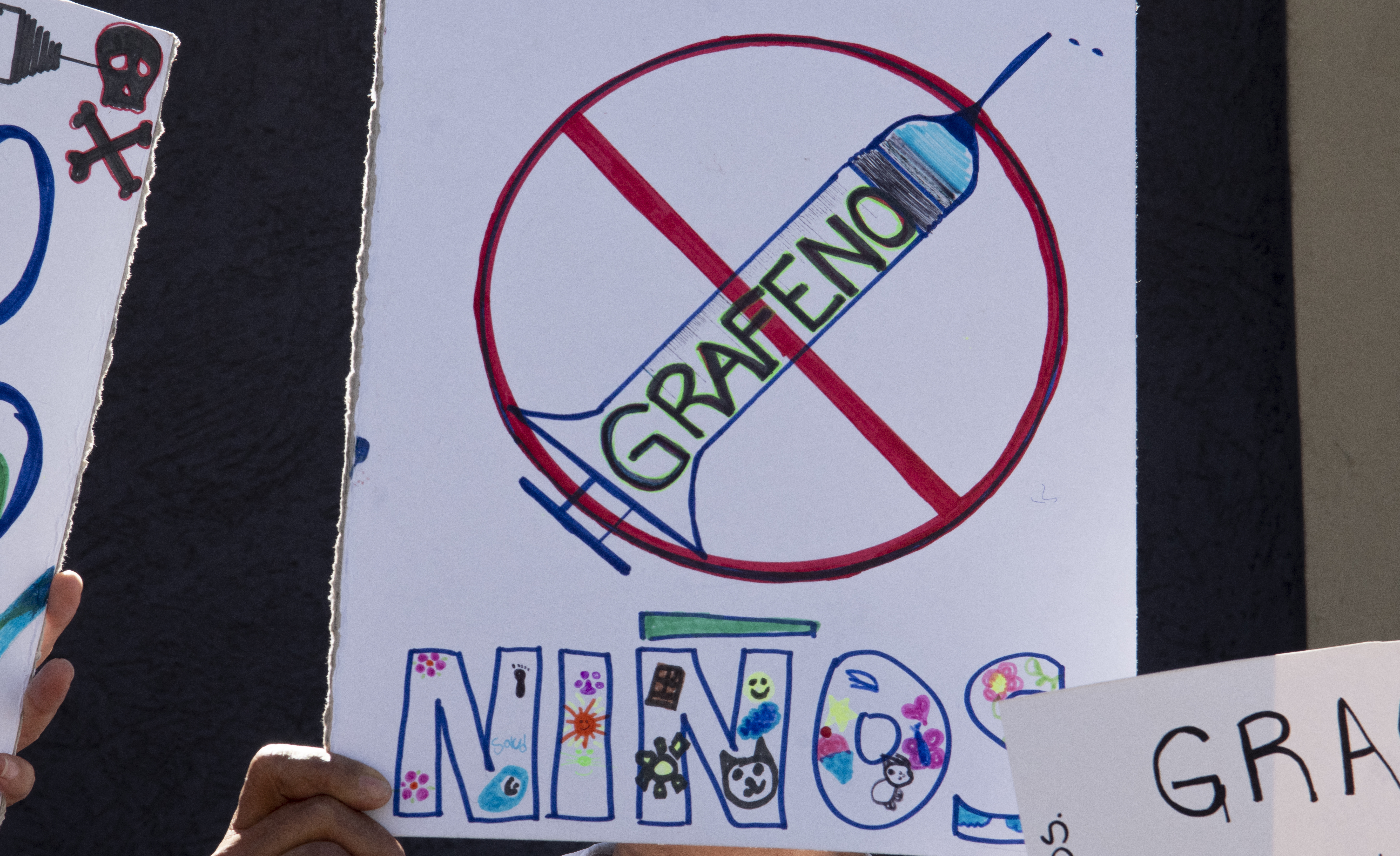 Una mujer sostiene un cartel durante una manifestación contra la vacunación obligatoria COVID-19 para niños en San José, el 5 de enero de 2022. (Photo by Ezequiel BECERRA / AFP)