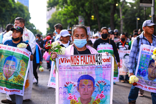 Manifestante sostiene una pancarta durante una manifestación para conmemorar el octavo aniversario de la desaparición de los estudiantes de Ayotzinapa el 26 de septiembre de 2022 en la Ciudad de México, México. El 26 de septiembre de 2014, 43 estudiantes de la Escuela Rural Isidro Burgos de Ayotzinapa desaparecieron en la ciudad de Iguala tras enfrentamientos con fuerzas policiales. Los estudiantes fueron acusados de intentar el secuestro de autobuses para ser utilizados en protestas. (Foto de Manuel Velásquez/Getty Images)