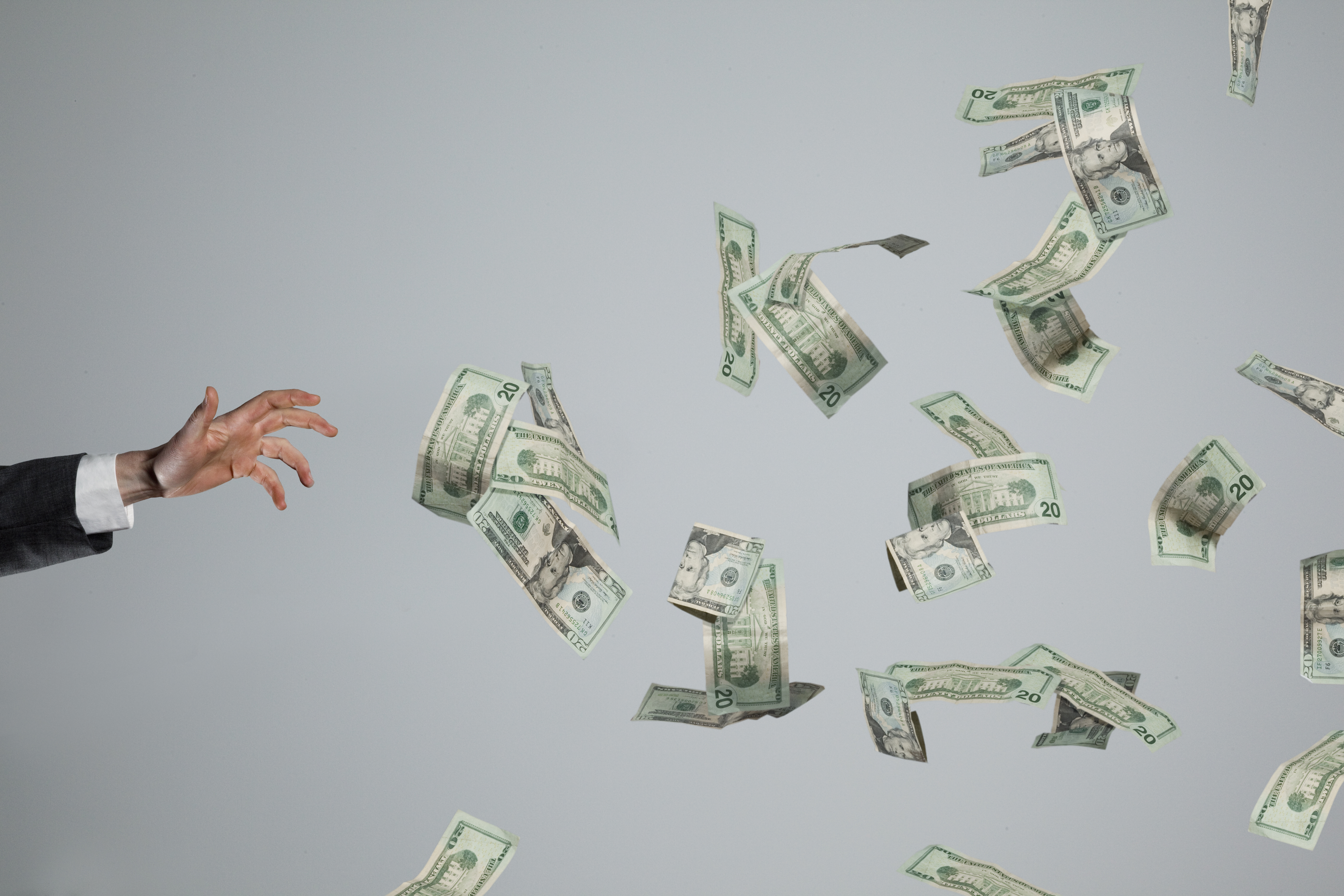 Hand grasping at fluttering money