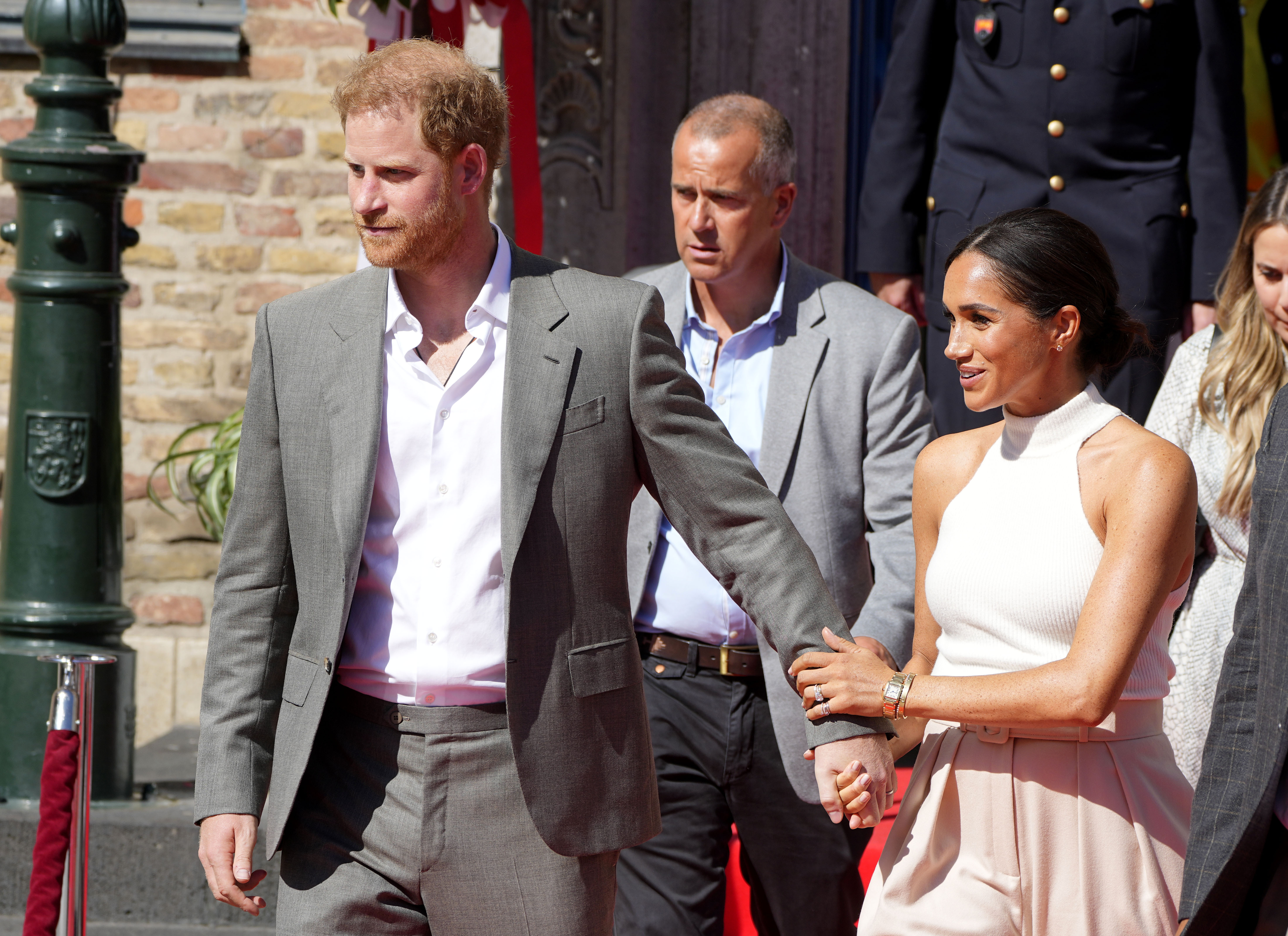 El príncipe Harry de Gran Bretaña, a la izquierda, y Meghan, duquesa de Sussex, salen del ayuntamiento en Düsseldorf, Alemania, el martes 6 de septiembre de 2022. El príncipe Harry visita la ciudad como embajador de los juegos Invictus, juegos de una semana para militares activos y veteranos que están enfermos, lesionados o heridos, será el anfitrión de Düsseldorf el próximo año. (AP Photo/Martin Meissner).