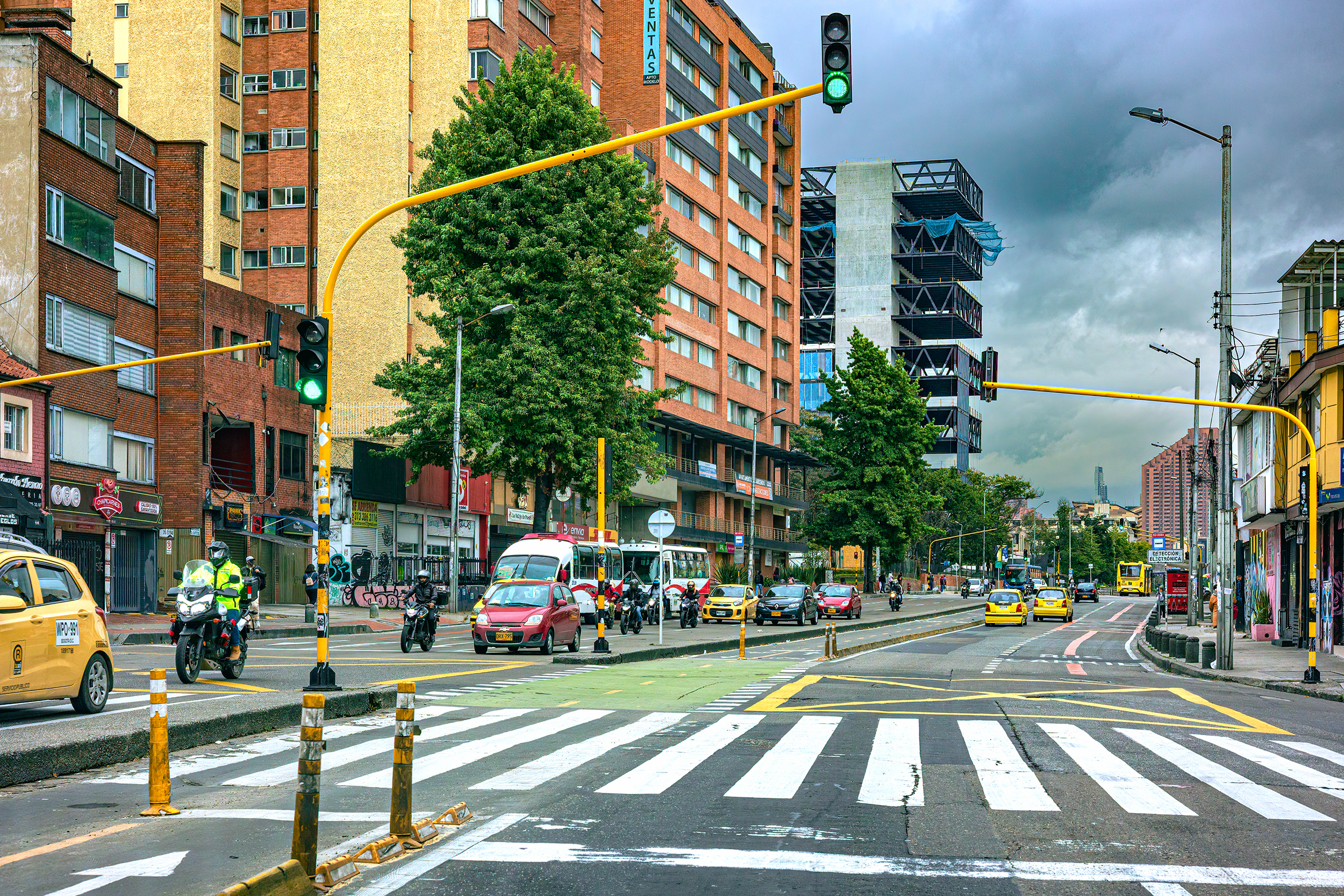 Bogotá, Colombia - 08 de octubre de 2021: El punto de vista de los conductores en la calzada sur de la Carrera Septima que atraviesa la zona de Chapinero en la capital andina de Bogotá, en América del Sur. A la izquierda están las calzadas en dirección norte y los carriles exclusivos para bicicletas. La ciudad es famosa por su extensa red de carriles bici. El carril Bus se puede ver a la derecha: deja un solo carril para que compita el resto del tráfico en dirección sur. A ambos lados de la arteria principal hay edificios residenciales y de oficinas. La altitud al nivel de la calle es de 8,660 pies sobre el nivel medio del mar. Formato horizontal. Copie el espacio.