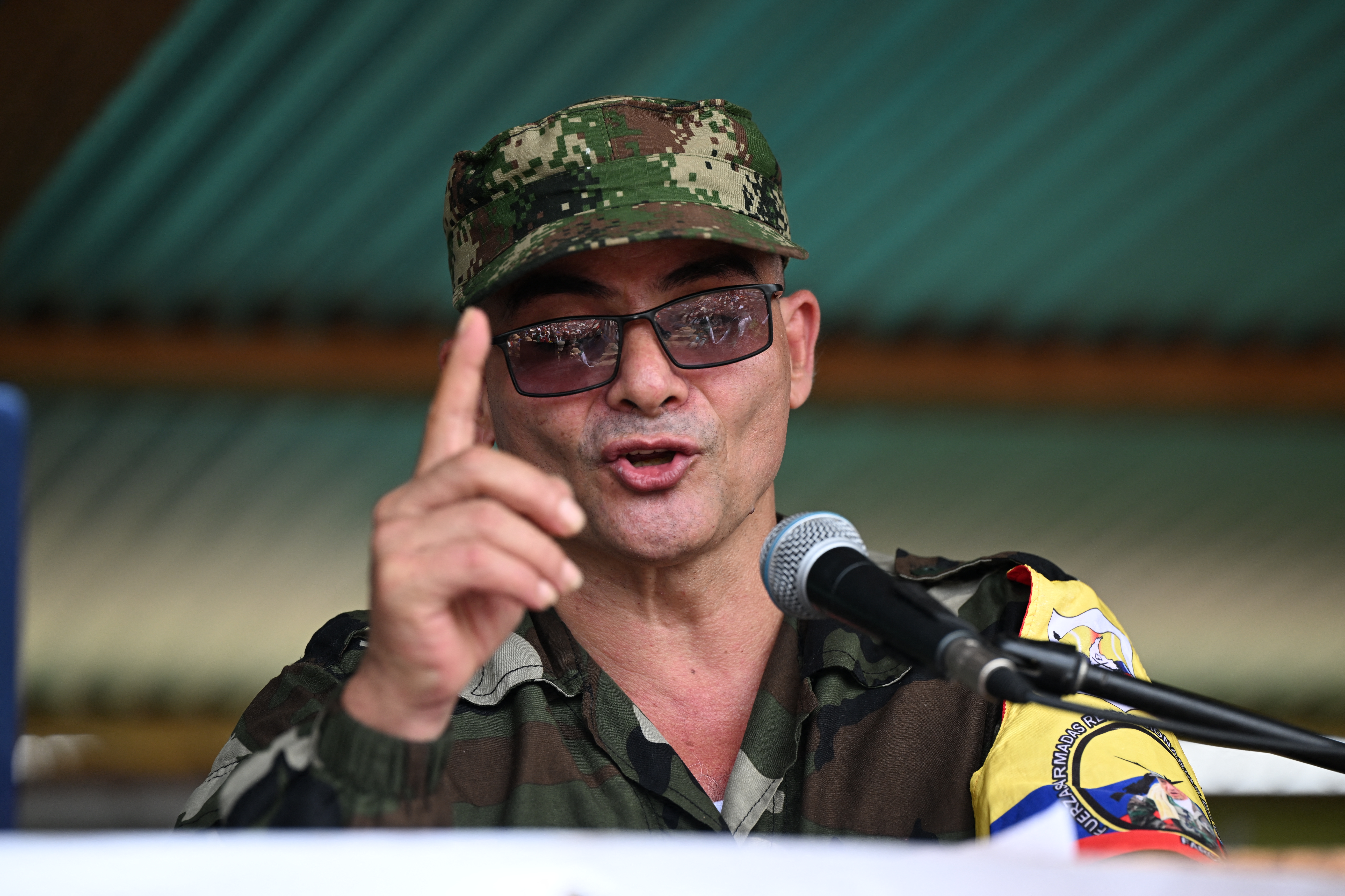 FARC-EP dissidence top commander, aka Ivan Mordisco (C), speaks during a meeting with local communities in San Vicente del Caguan, Caqueta department, Colombia, on April 16, 2023. An armed dissident group of Colombia's disbanded FARC guerrillas said Sunday it was "ready" to start peace talks with the government from May 16. "We are announcing to the world that our delegates to the dialogue table with the Colombian government... are ready for May 16," the EMC dissident grouping, which rejected a 2016 peace deal that disarmed the FARC, said through a spokesperson. (Photo by JOAQUIN SARMIENTO / AFP)