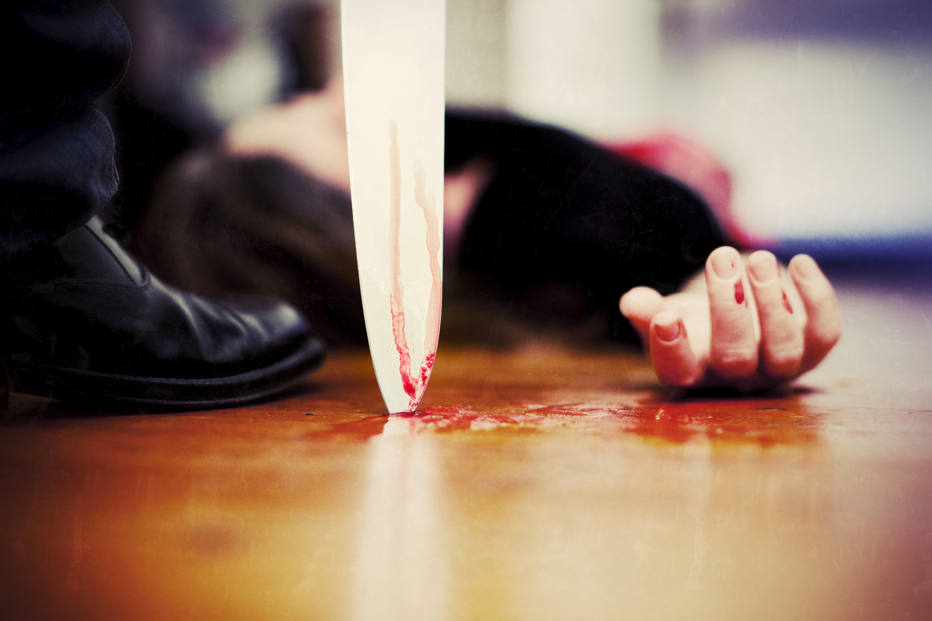 "Close up on a bloody knife planted on a wooden floor, a killing scene"