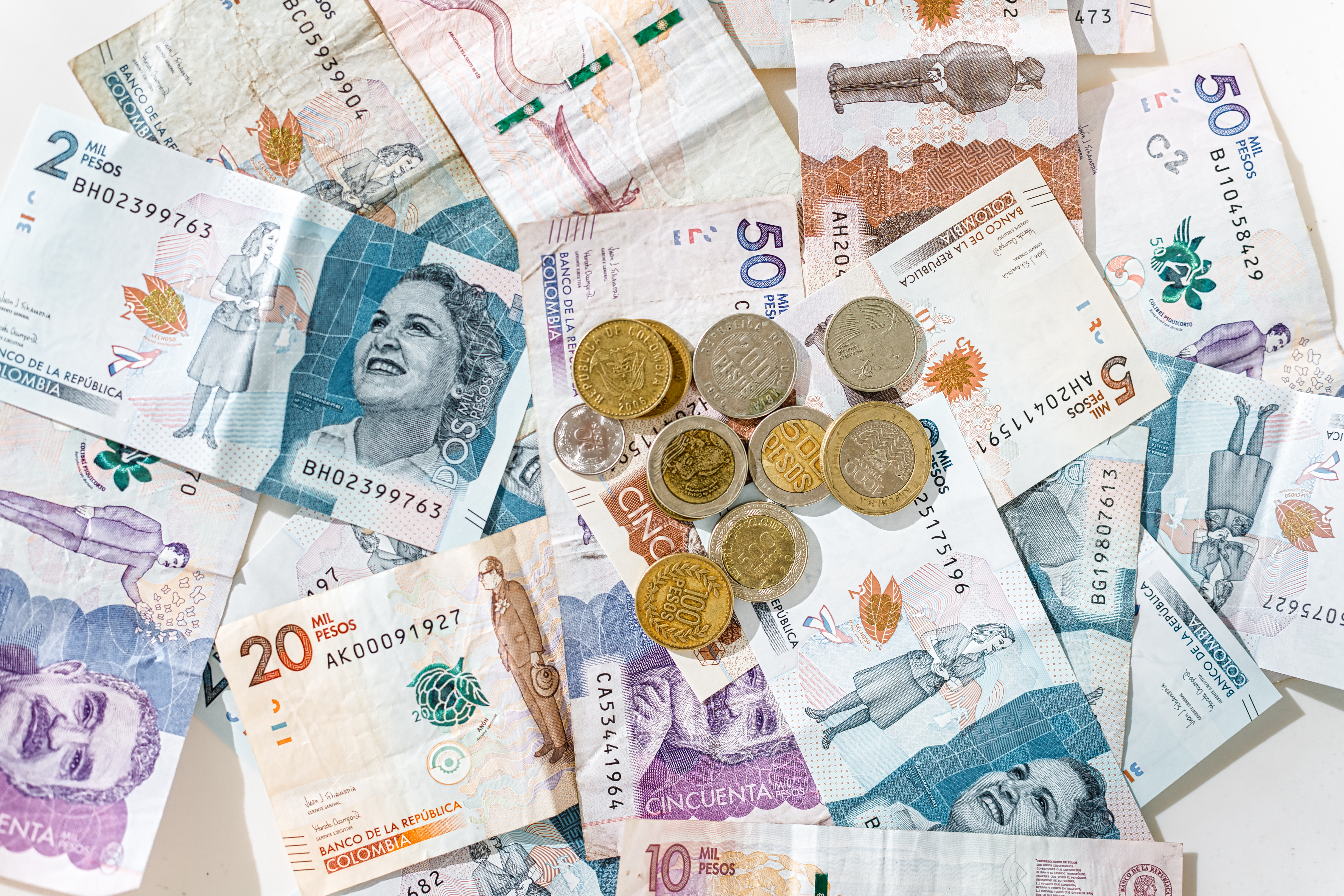 Monedas de pesos colombianos en billetes de diferentes denominaciones