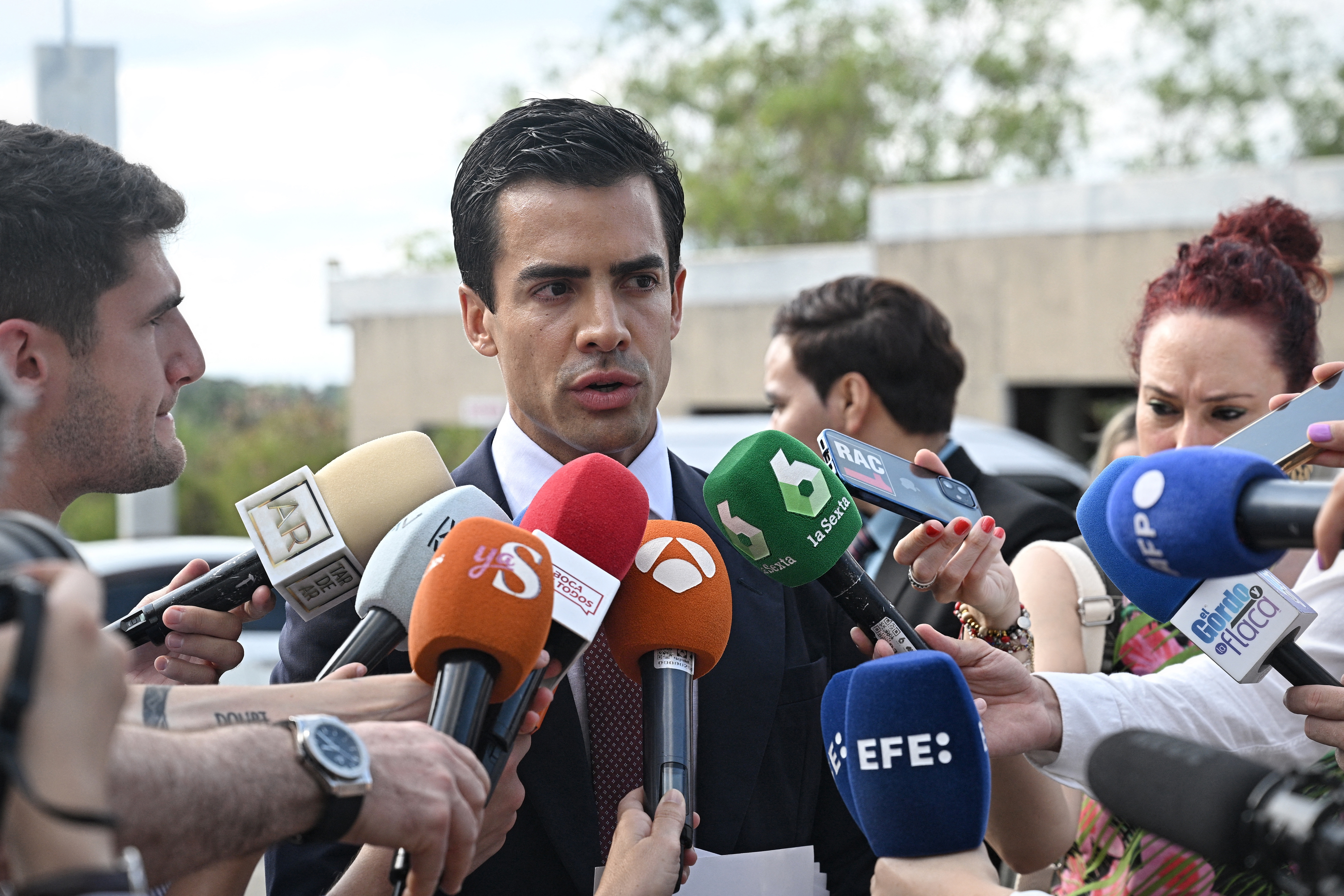 Juan Gonzalo Ospina, abogado de la familia del cirujano plástico colombiano Edwin Arrieta Arteaga, habla con los medios antes de asistir al interrogatorio de testigos para el juicio a Daniel Sancho Bronchalo. (Foto de Lillian SUWANRUMPHA / AFP)