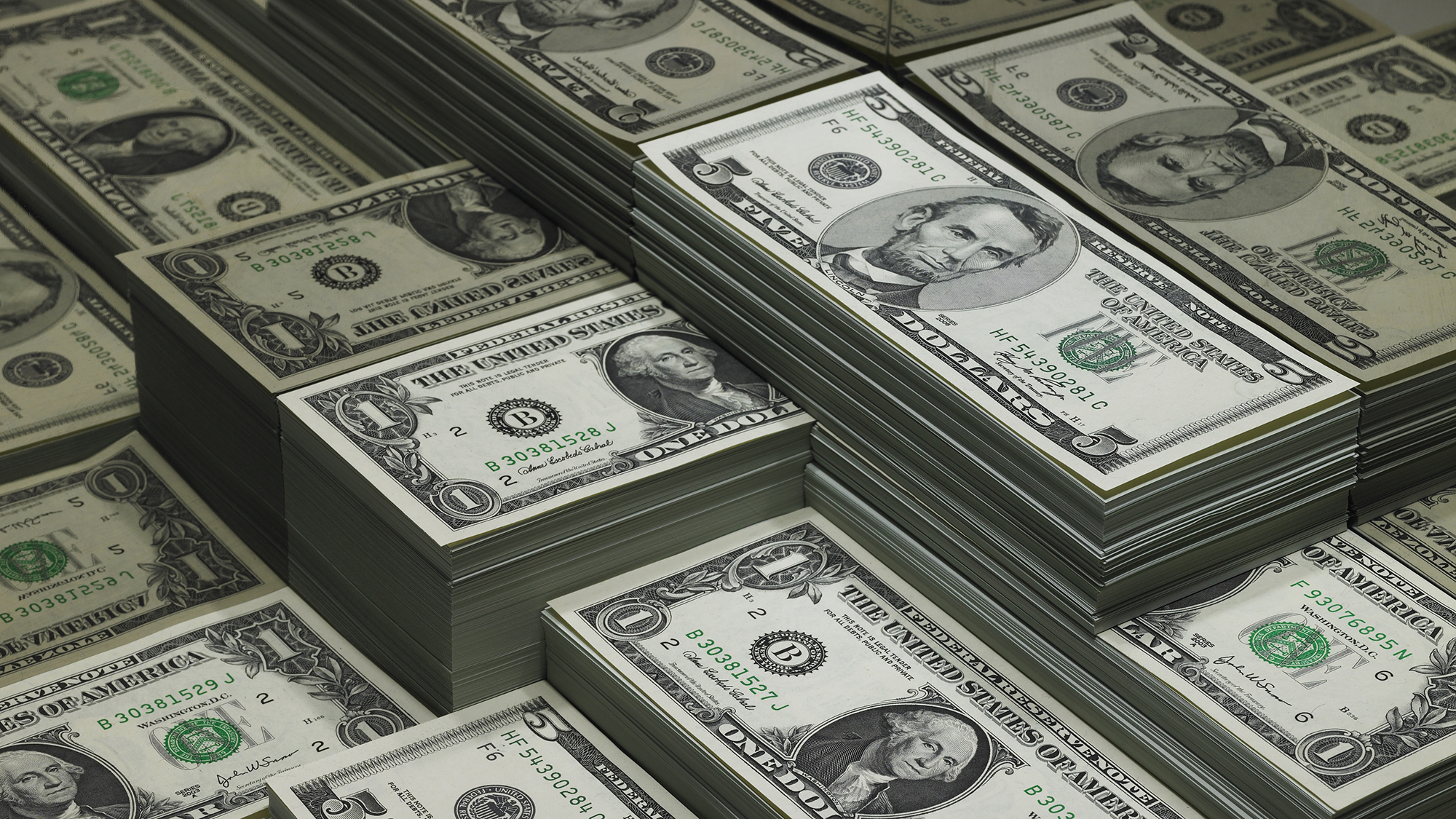 montones de billetes de dólar reflejados en vidrio