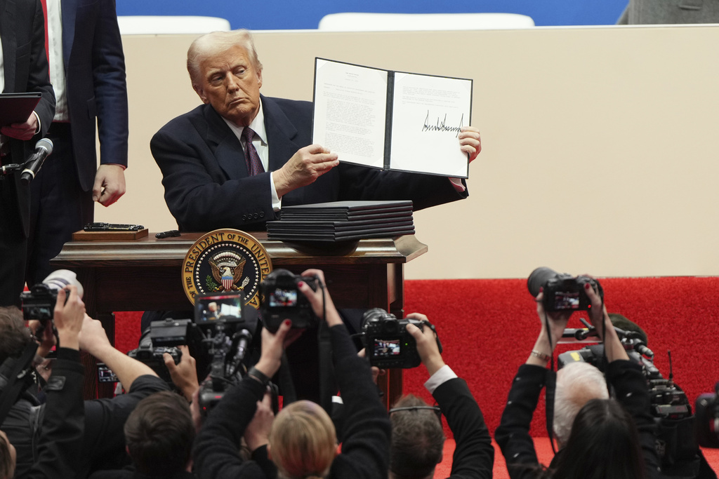 El presidente Donald Trump sostiene una orden ejecutiva después de firmarla en un desfile de inauguración presidencial bajo techo en Washington, el lunes 20 de enero de 2025. (Foto AP/Matt Rourke
