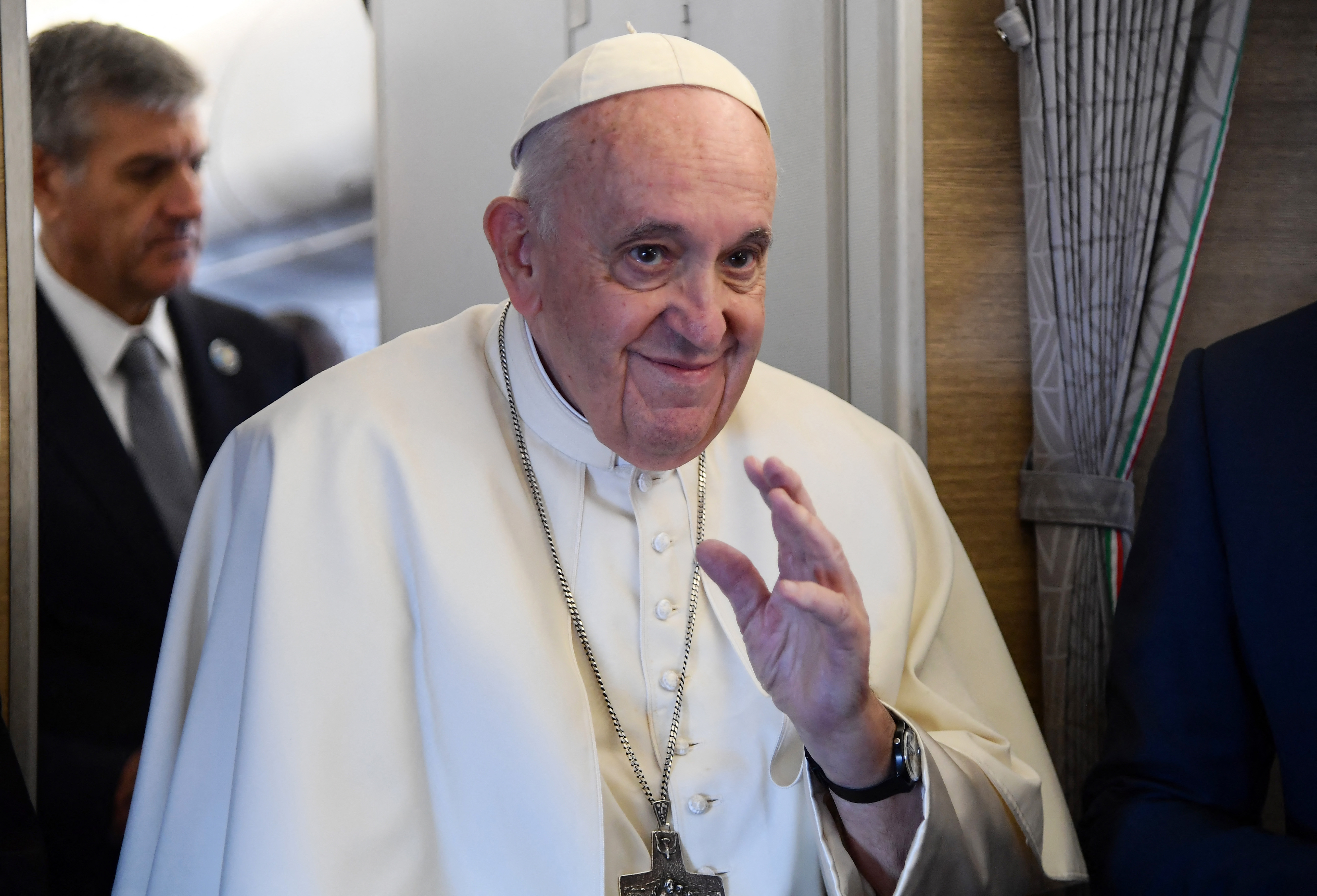 Pope Francis greets the media on board the papal plane enroute to the Kazakh capital of Nur-Sultan at the start of his three-day visit to the Central Asian country, on September 13, 2022. (Photo by Filippo MONTEFORTE / POOL / AFP)