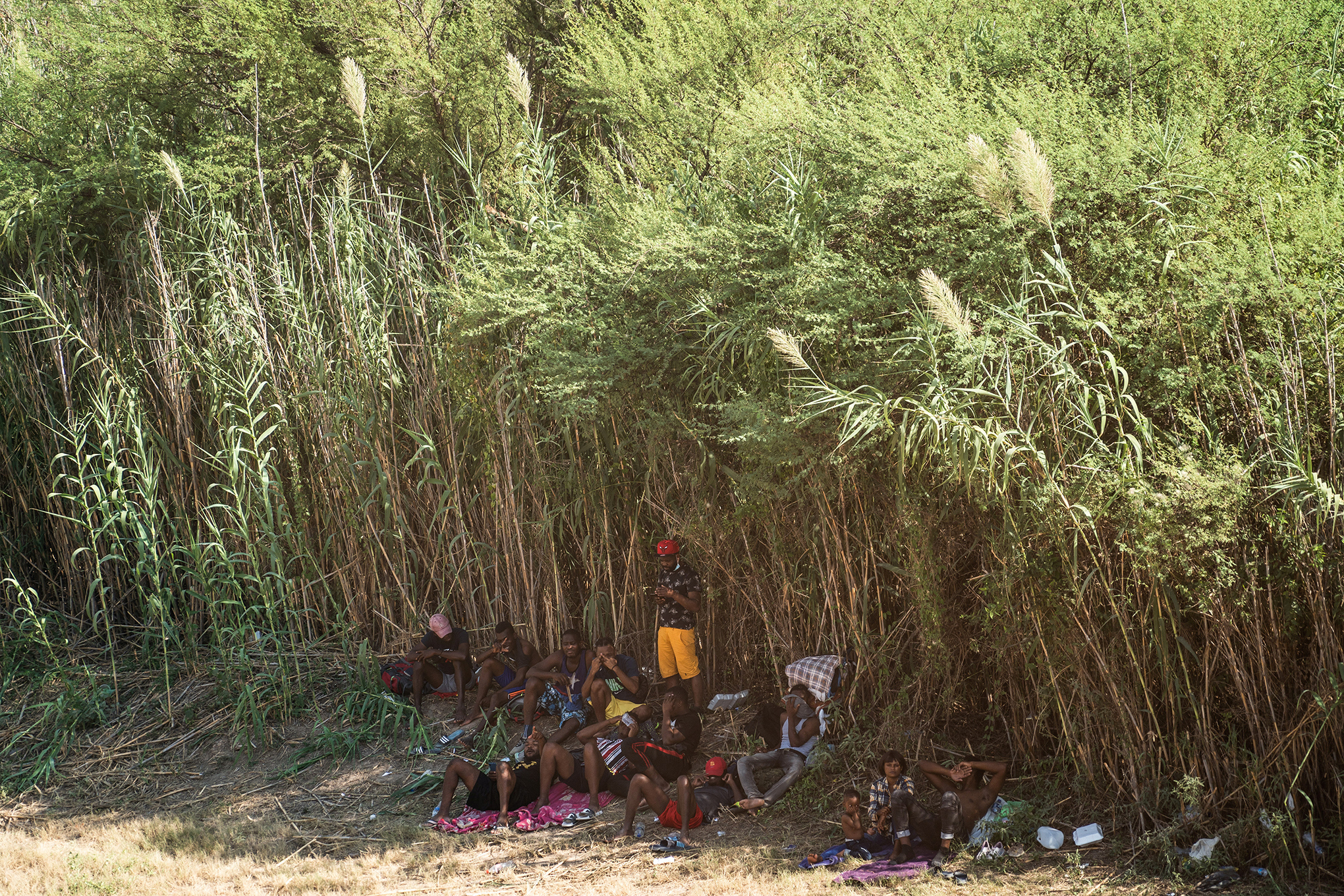 Migrantes solicitantes de asilo caminan bajo el Puente Internacional entre México y Estados Unidos. Foto REUTERS / Go Nakamura