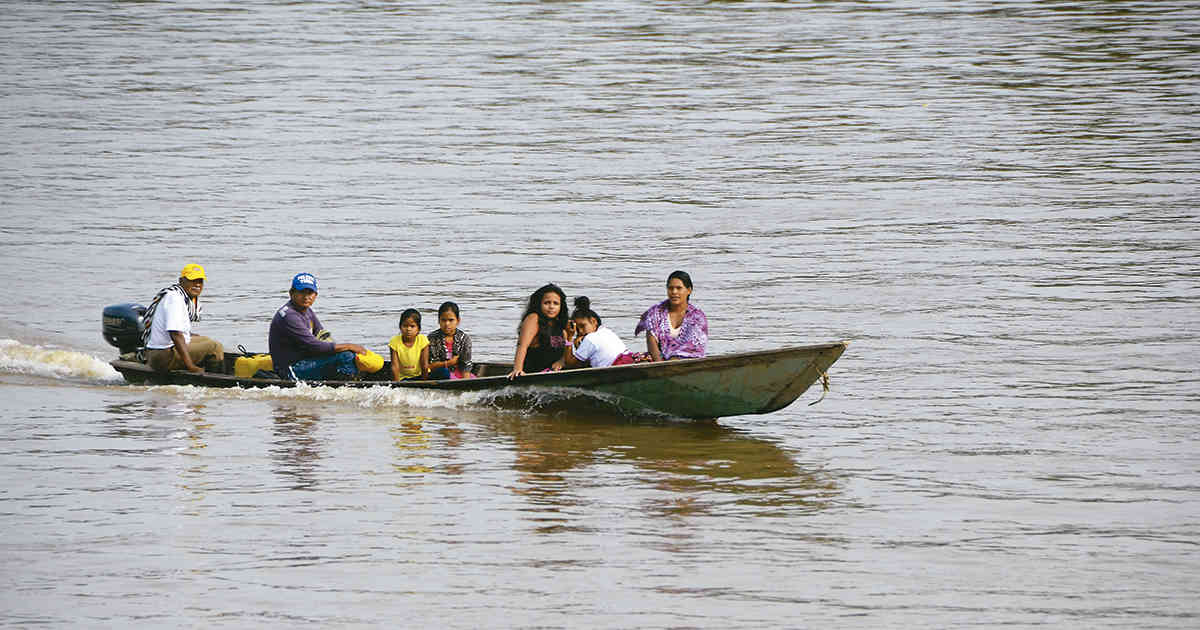 Una familia surca el río, una autopista que conecta centros poblados y países.