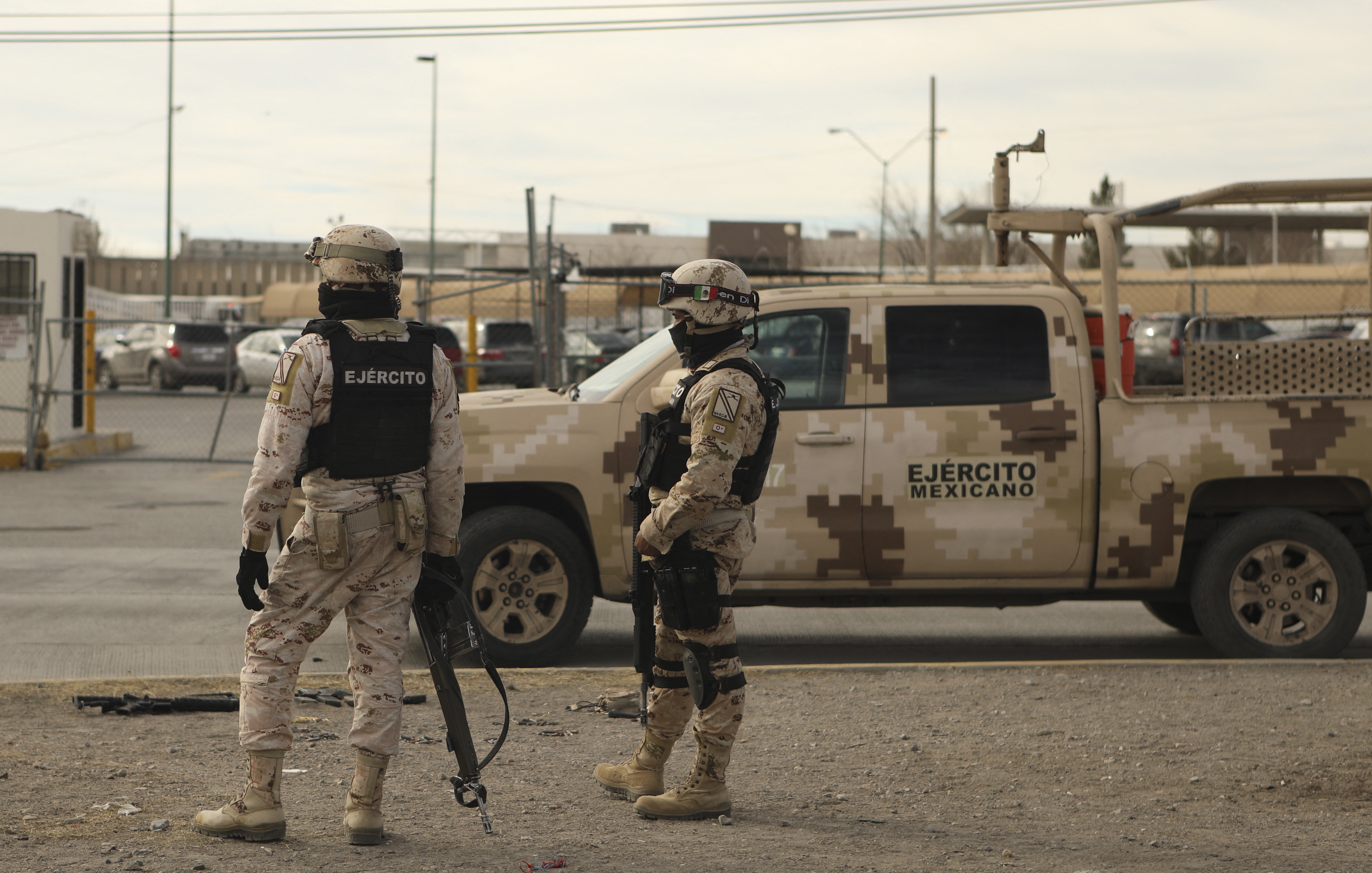 Miembros del Ejército Mexicano junto a un rifle semiautomático (L, en el piso) y cartuchos encontrados afuera de la prisión de Ciudad Juárez luego de un ataque en Ciudad Juárez, estado de Chihuahua, el 1 de enero de 2023. - Hombres armados atacaron una prisión en la norteña ciudad mexicana de Ciudad Juárez el domingo, dejando 14 muertos y permitiendo la fuga de 24 reclusos, dijo la fiscalía del estado de Chihuahua. Un número desconocido de hombres armados a bordo de vehículos blindados participó en el ataque, y entre los muertos había diez oficiales penitenciarios y agentes de seguridad, dijo en un comunicado. (Foto por HERIKA MARTÍNEZ / AFP)