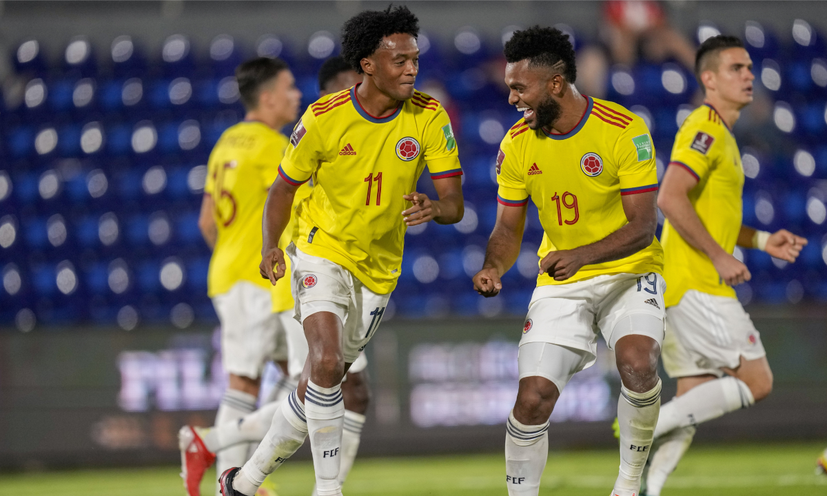 Colombia's Juan Cuadrad, left, celebrates with teammate Miguel Borja after scoring from the penalty spot his side's opening goal against Paraguay during a qualifying soccer match for the FIFA World Cup Qatar 2022 in Asuncion, Paraguay, Sunday, Sept. 5, 2021. (AP Photo/Jorge Saenz)