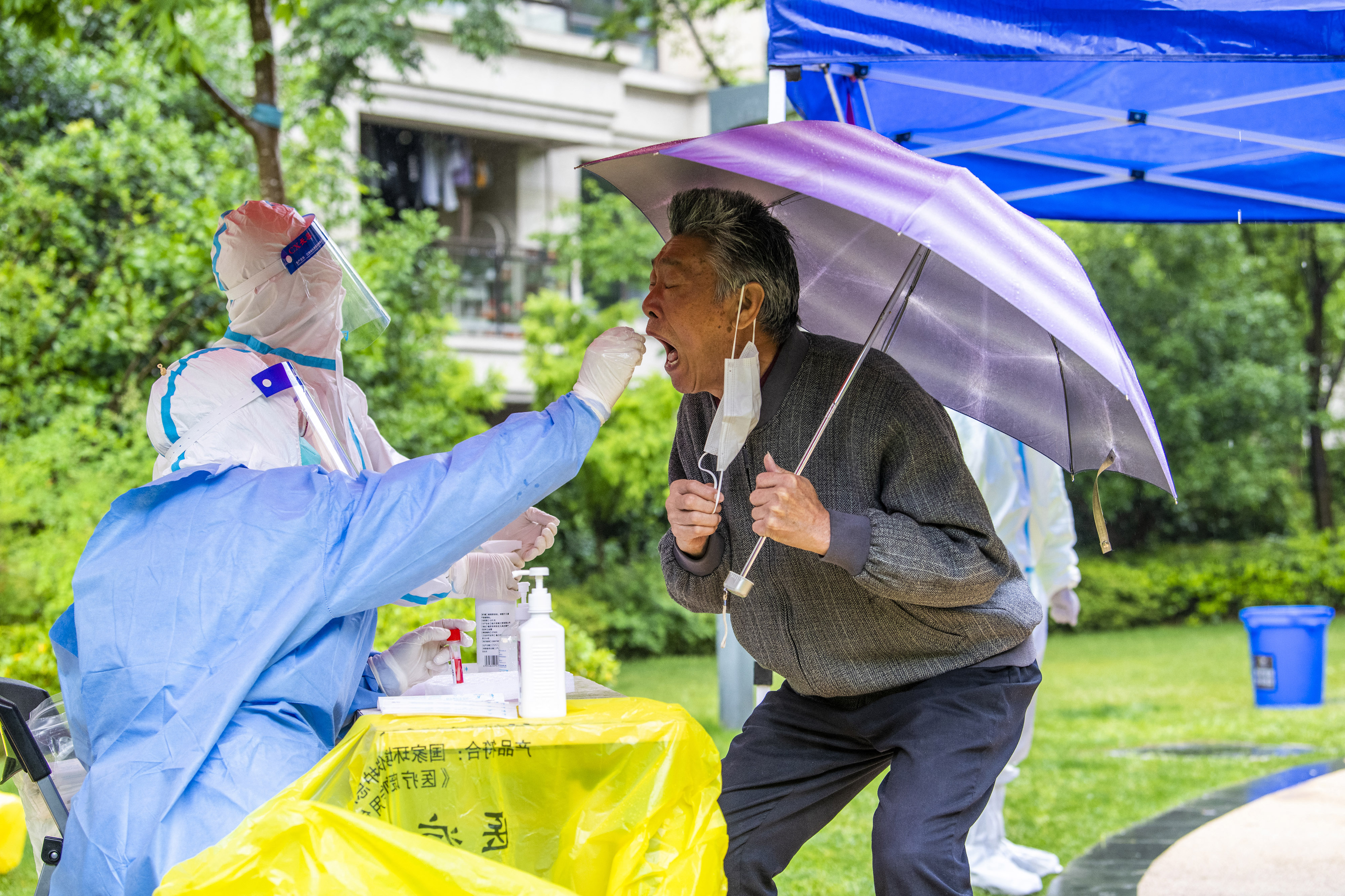 Un trabajador de la salud toma una muestra de un hisopo de un residente para hacerle la prueba del coronavirus Covid-19 (Foto de LIU JIN / AFP) / China OUT