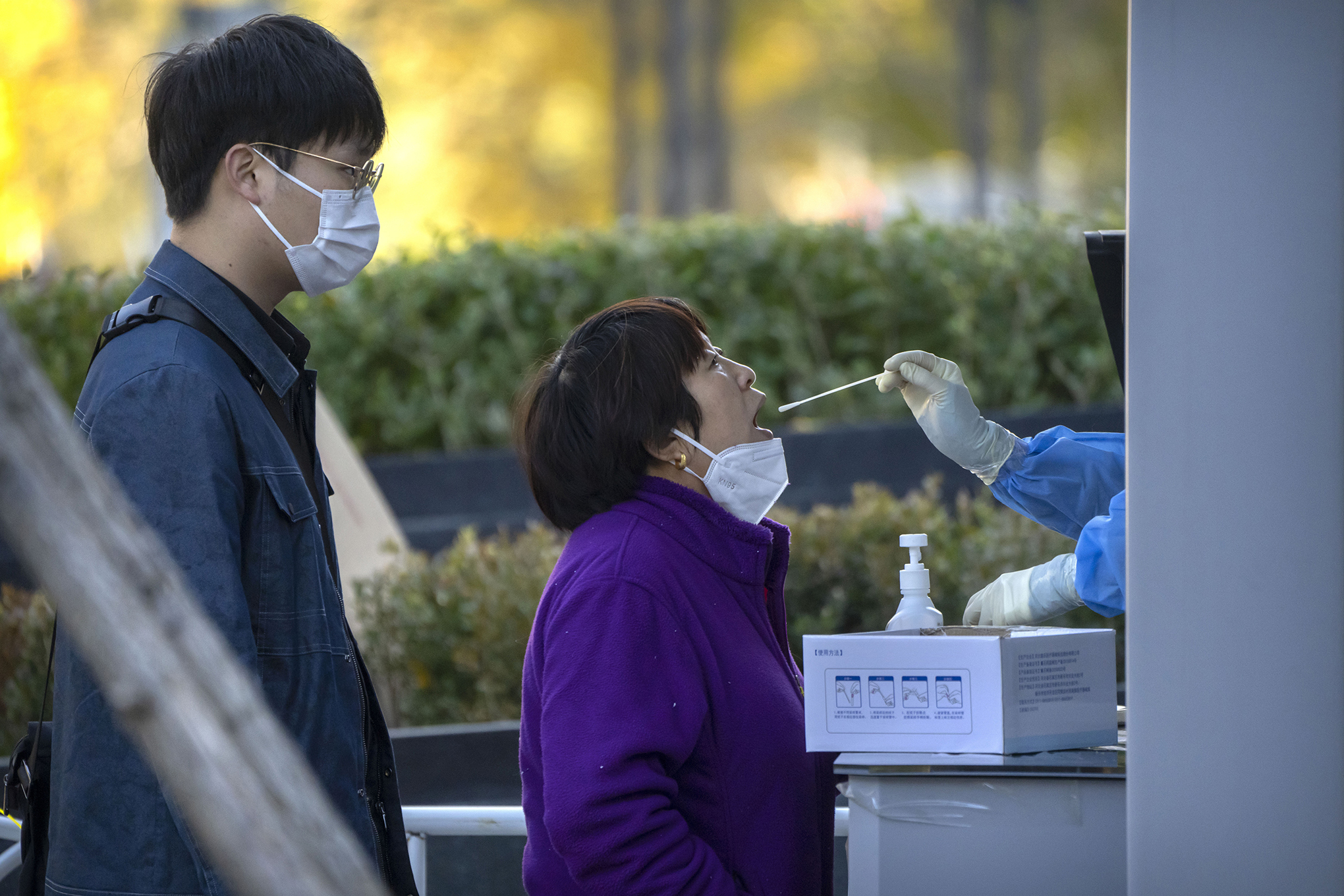 A una mujer le toman una muestra de la garganta para una prueba de COVID-19 en un sitio de pruebas de coronavirus en Beijing, el viernes 4 de noviembre de 2022. 