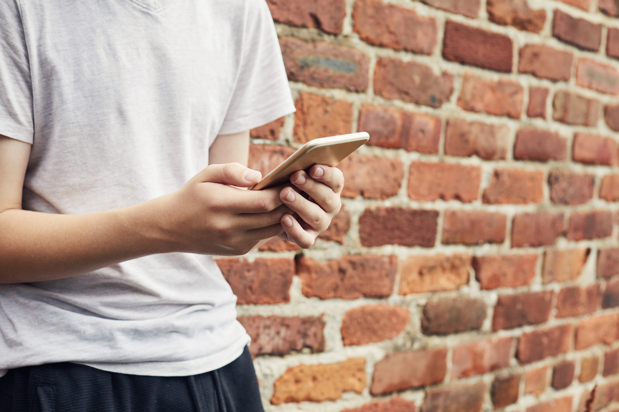 Close up of a teenage boys hands using a smartphone
