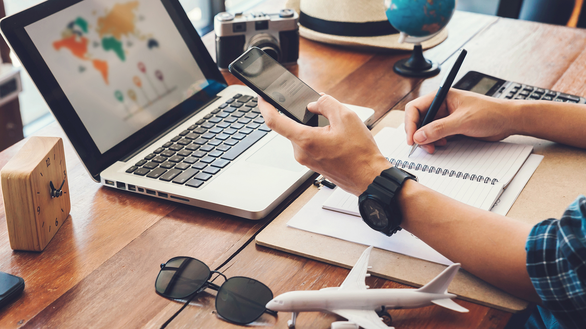 Hombres jóvenes que planean un viaje de vacaciones y buscan información o reservan un hotel en un teléfono inteligente y una computadora portátil. viajes, vacaciones de viaje,