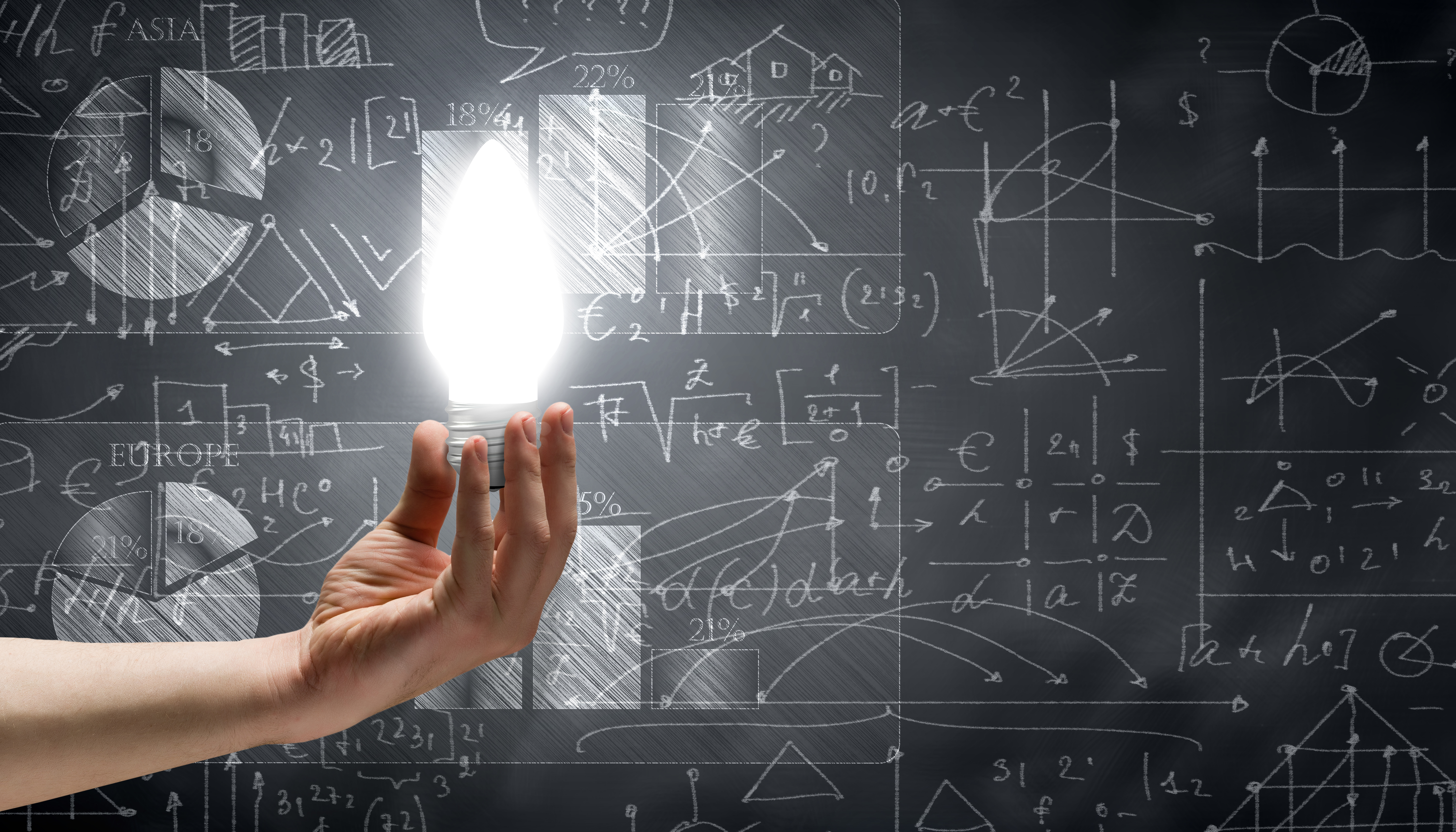 Primer plano de la mano que sostiene la bombilla con bocetos en el fondo