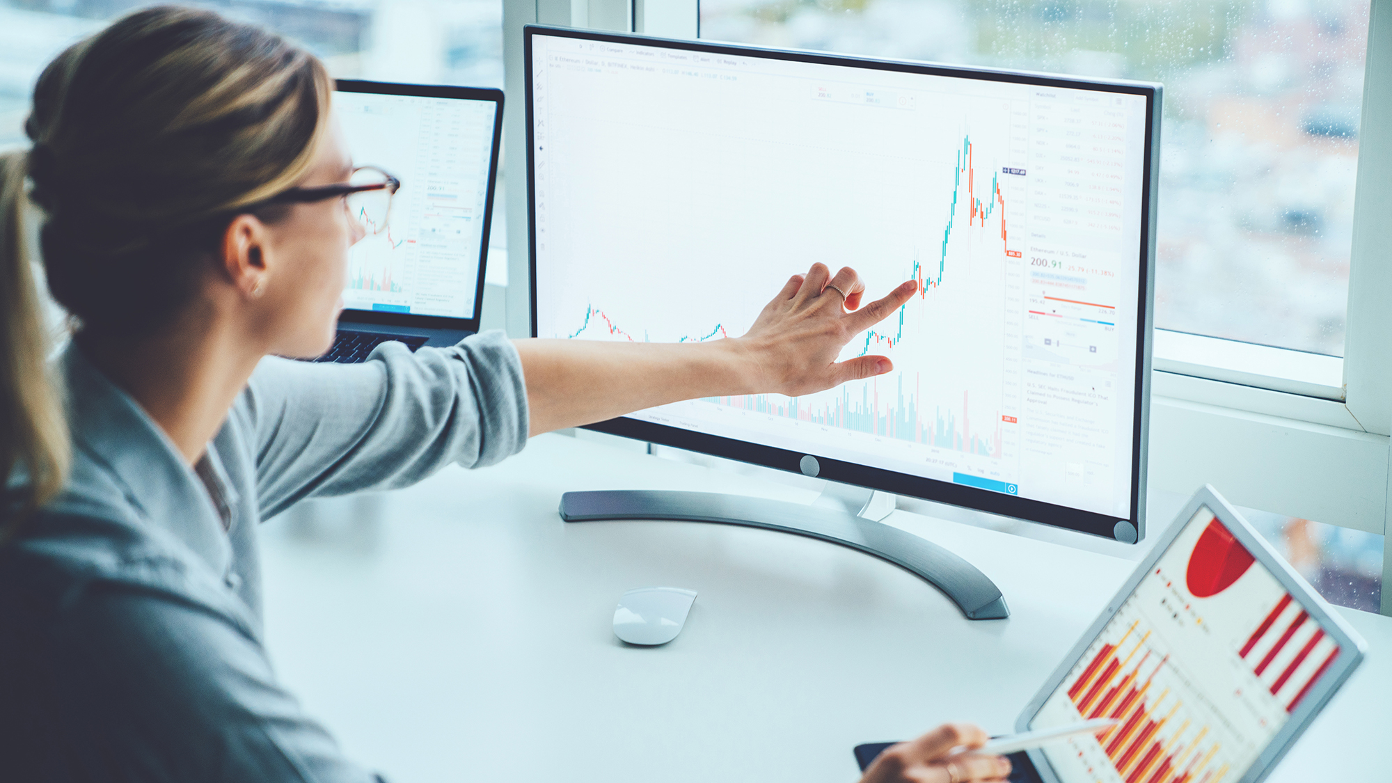 Mujer de negocios estudio mercado financiero para calcular posibles riesgos y beneficios. Mujer economista contabilidad dinero con gráficos de estadísticas apuntando en la pantalla de la computadora en el escritorio. Cotizaciones en bolsa