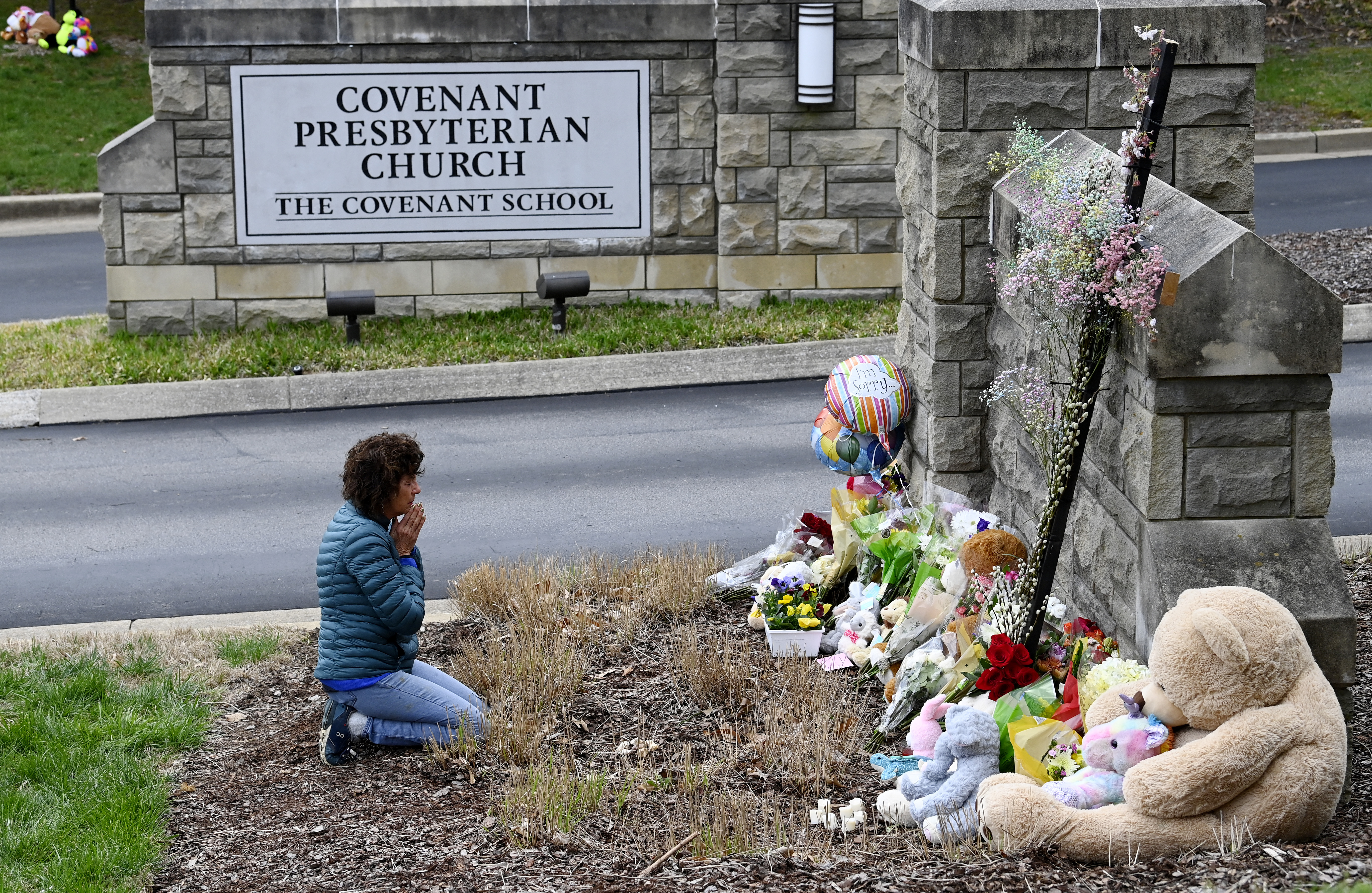 Robin Wolfeden reza frente a un monumento improvisado en la entrada de The Covenant School el martes 28 de marzo de 2023 en Nashville, Tennessee. (Mark Zaleski /The Tennessean via AP)