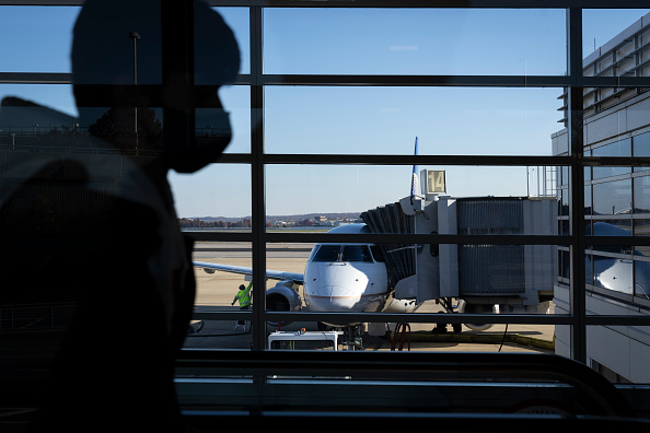 ARLINGTON, VA - NOVEMBER 23: Travelers walk through Terminal A at Ronald Reagan Washington National Airport November 23, 2021 in Arlington, Virginia. With Covid-19 vaccinations on the rise and Americans now traveling more freely, U.S. airports and airlines are expecting millions more passengers this holiday season compared to 2020. (Photo by Drew Angerer/Getty Images)