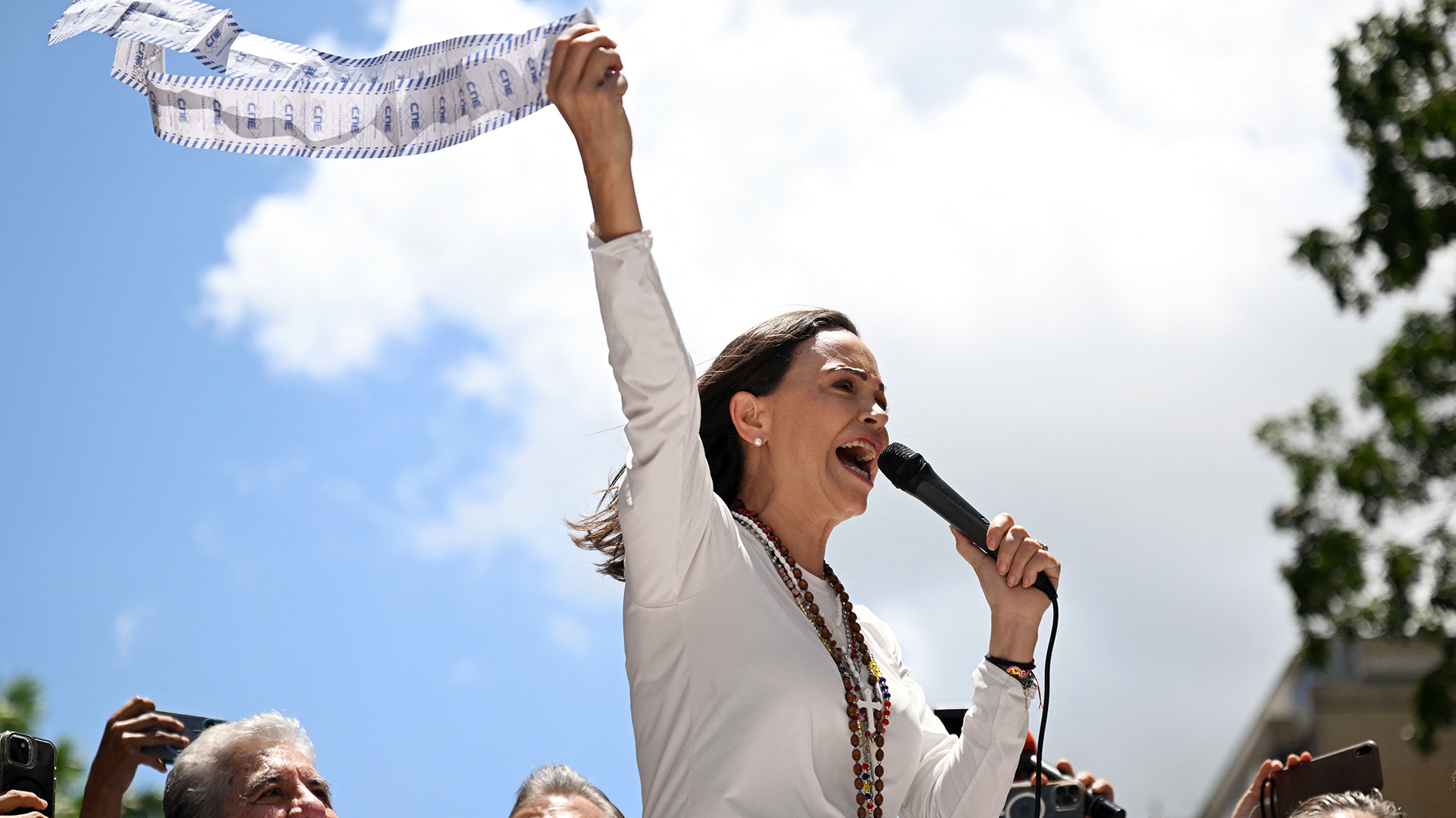 Venezuelan opposition leader Maria Corina Machado speaks to supporters while holding up electoral records during a rally in Caracas on August 28, 2024. Venezuela's opposition supporters rallied on August 28, a month after the disputed re-election of President Nicolas Maduro, who armoured his cabinet with a strongman at the helm of law and order. (Photo by JUAN BARRETO / AFP)