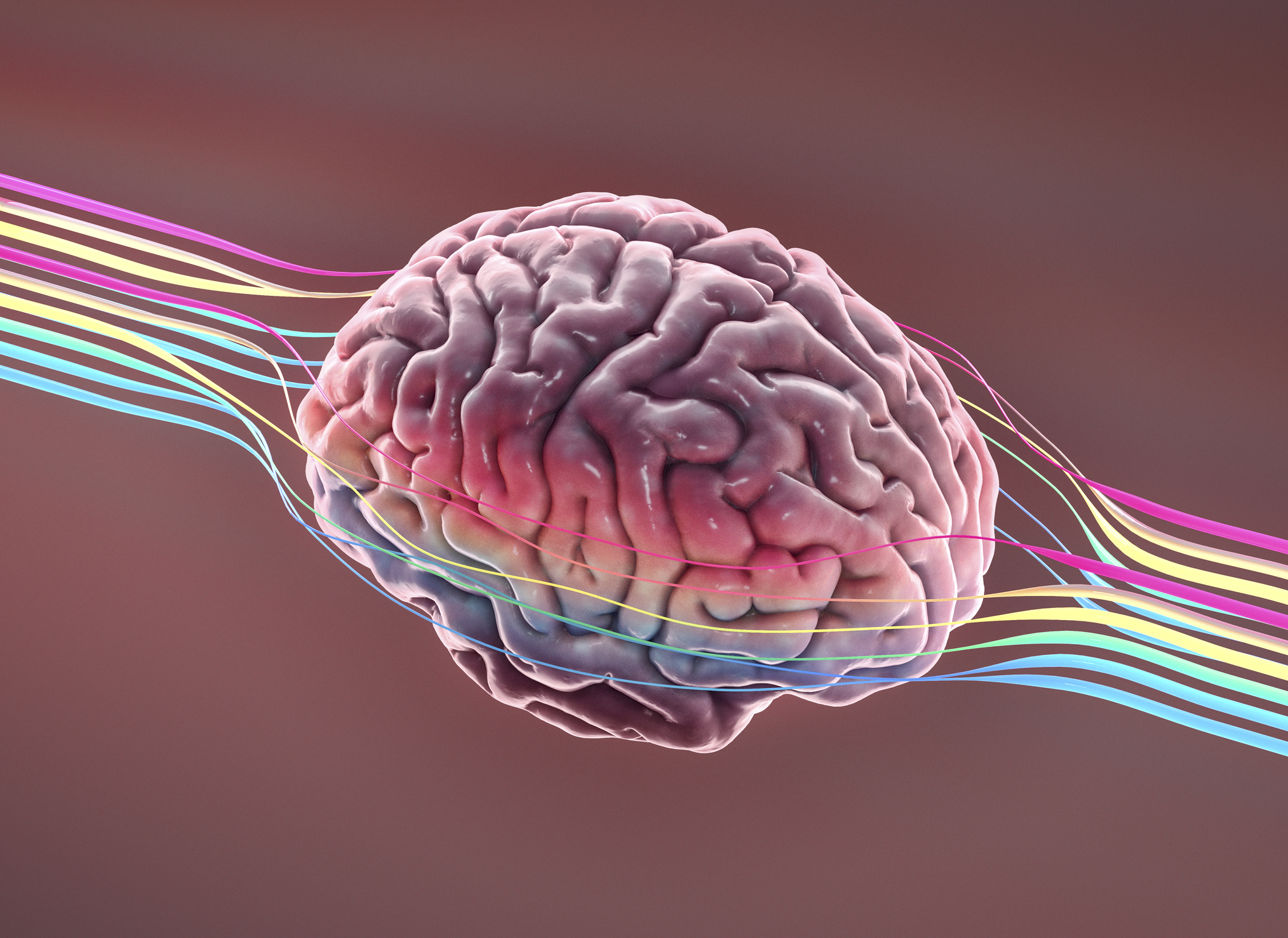 Un cerebro se sienta en el espacio con líneas de colores a su alrededor que representan pensamientos, ideas o creatividad